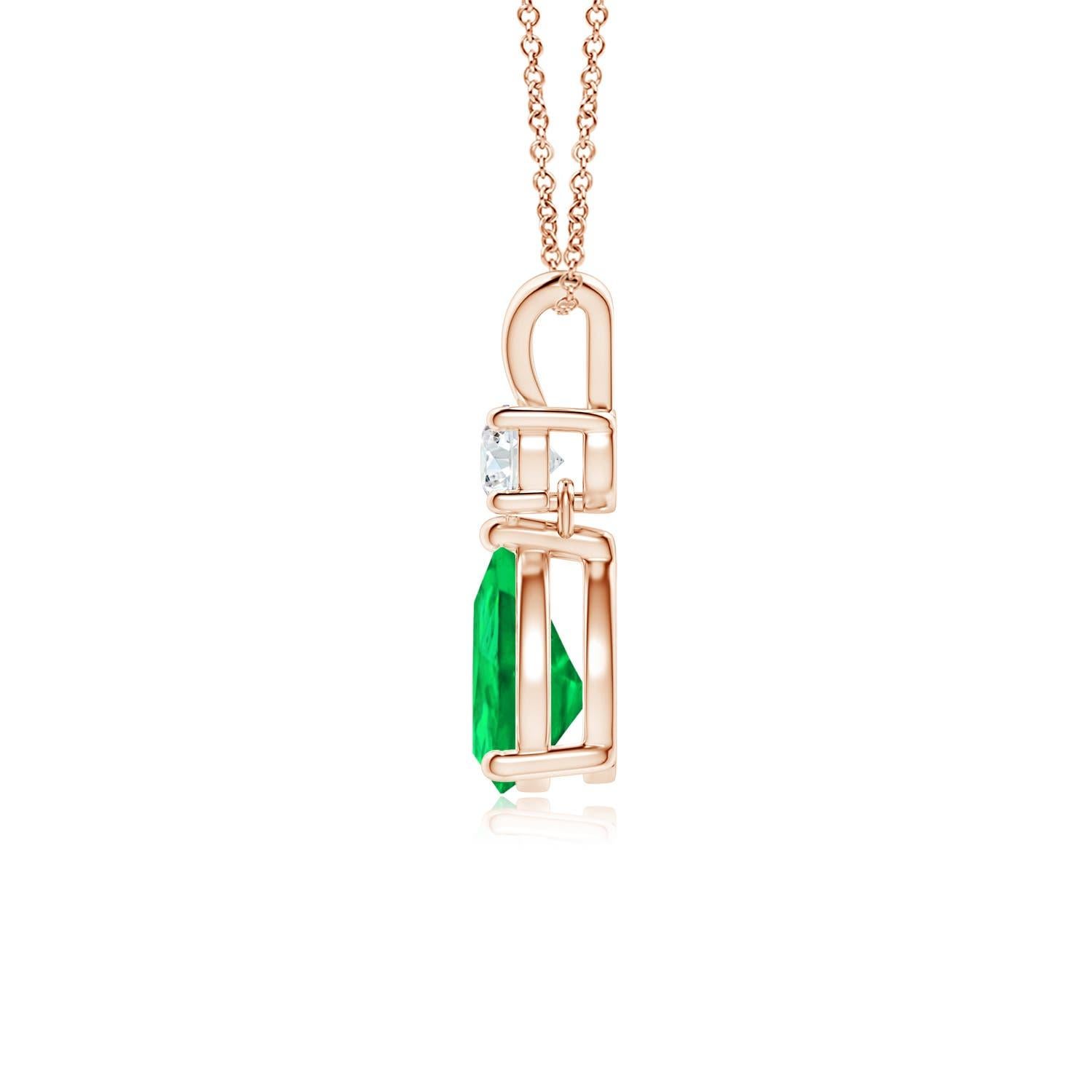 A vivid green pear cut emerald dangles from a sparkling white diamond on this elegant drop pendant. The lustrous V bale adds beauty to this 14k rose gold emerald and diamond pendant. It exudes luxurious charm with its remarkable long drop