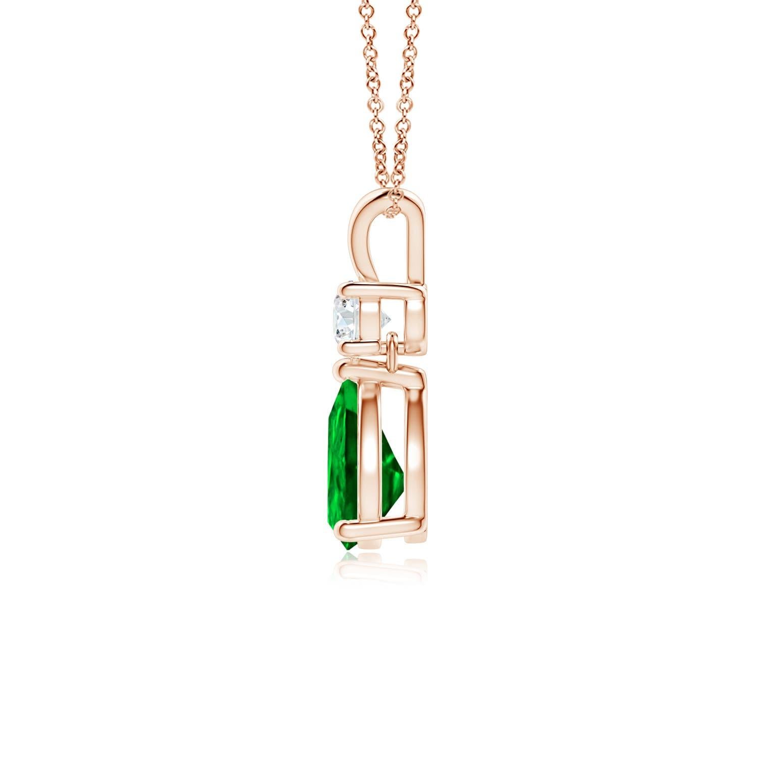 A vivid green pear cut emerald dangles from a sparkling white diamond on this elegant drop pendant. The lustrous V bale adds beauty to this 14k rose gold emerald and diamond pendant. It exudes luxurious charm with its remarkable long drop