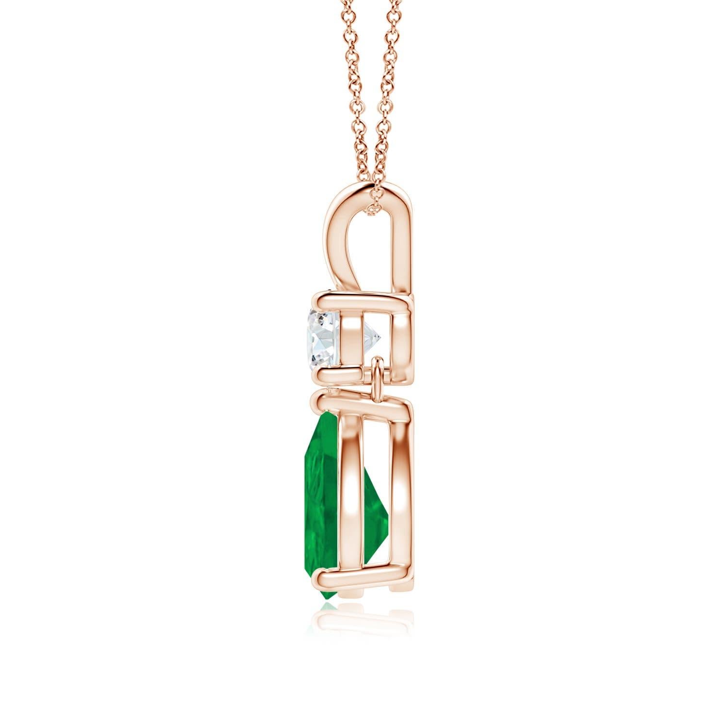 A vivid green pear cut emerald dangles from a sparkling white diamond on this elegant drop pendant. The lustrous V bale adds beauty to this 14k rose gold emerald and diamond pendant. It exudes luxurious charm with its remarkable long drop