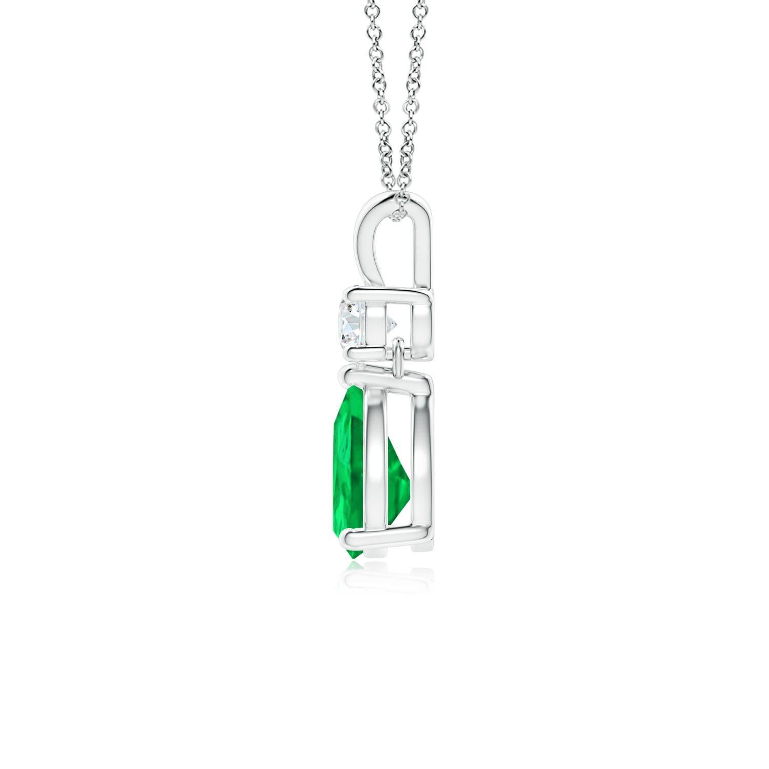 A vivid green pear cut emerald dangles from a sparkling white diamond on this elegant drop pendant. The lustrous V bale adds beauty to this 14k white gold emerald and diamond pendant. It exudes luxurious charm with its remarkable long drop