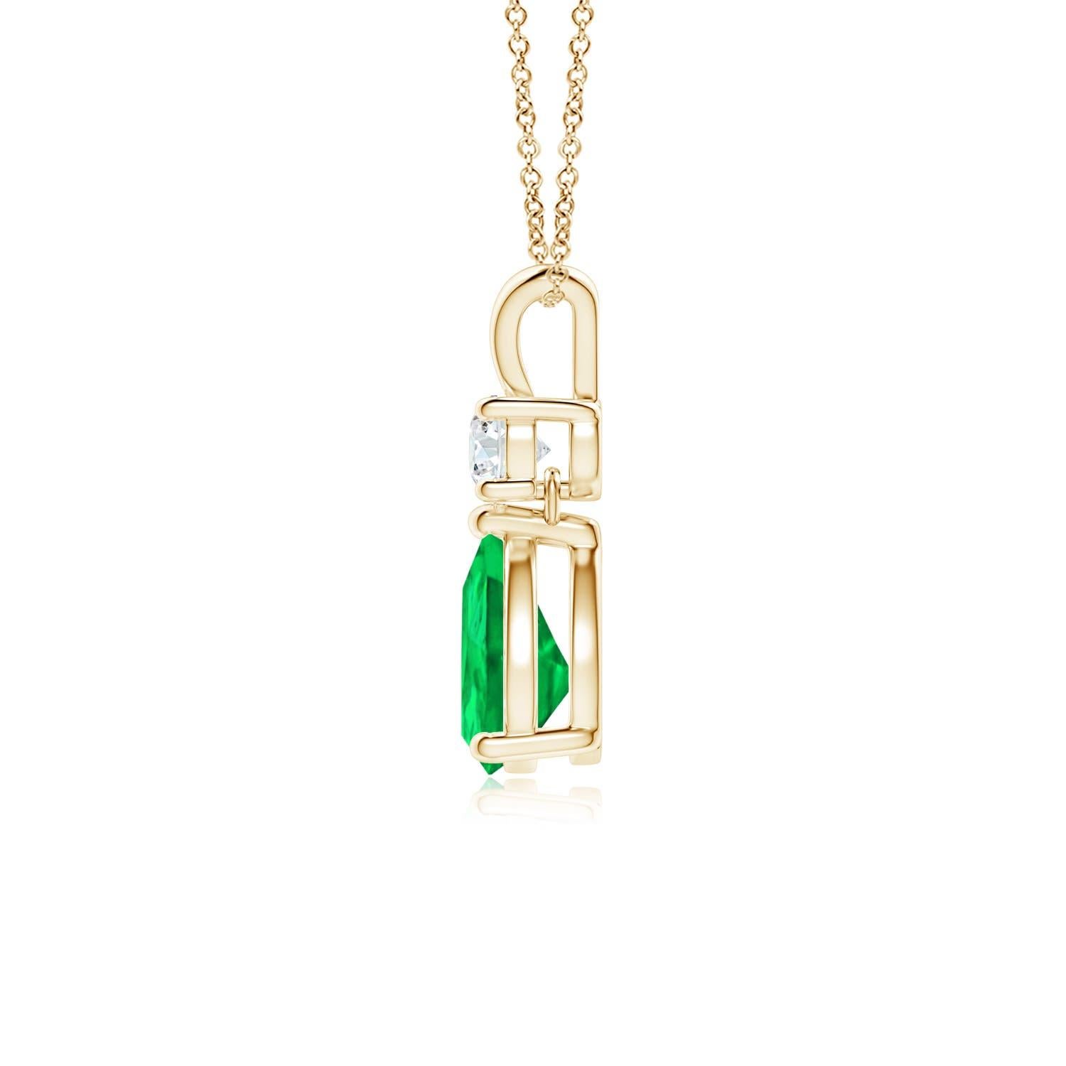 A vivid green pear cut emerald dangles from a sparkling white diamond on this elegant drop pendant. The lustrous V bale adds beauty to this 14k yellow gold emerald and diamond pendant. It exudes luxurious charm with its remarkable long drop