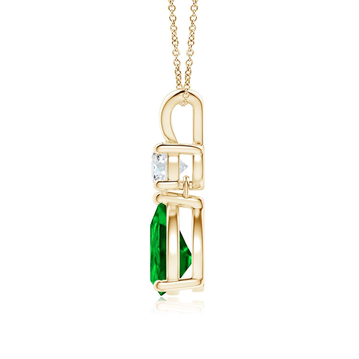 A vivid green pear cut emerald dangles from a sparkling white diamond on this elegant drop pendant. The lustrous V bale adds beauty to this 14k yellow gold emerald and diamond pendant. It exudes luxurious charm with its remarkable long drop