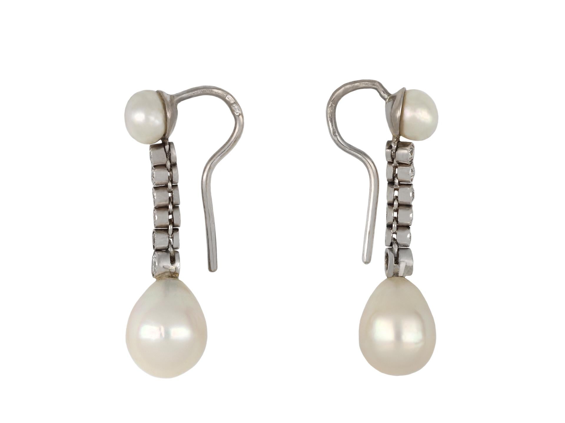 Natural pearl and diamond earrings. A matching pair of earrings, each set to bottom with one drop shape natural saltwater pearl, two in total, in closed back half drilled settings, one approximately 7.9 x 8.0 x 9.9mm, the other approximately 7.9 x