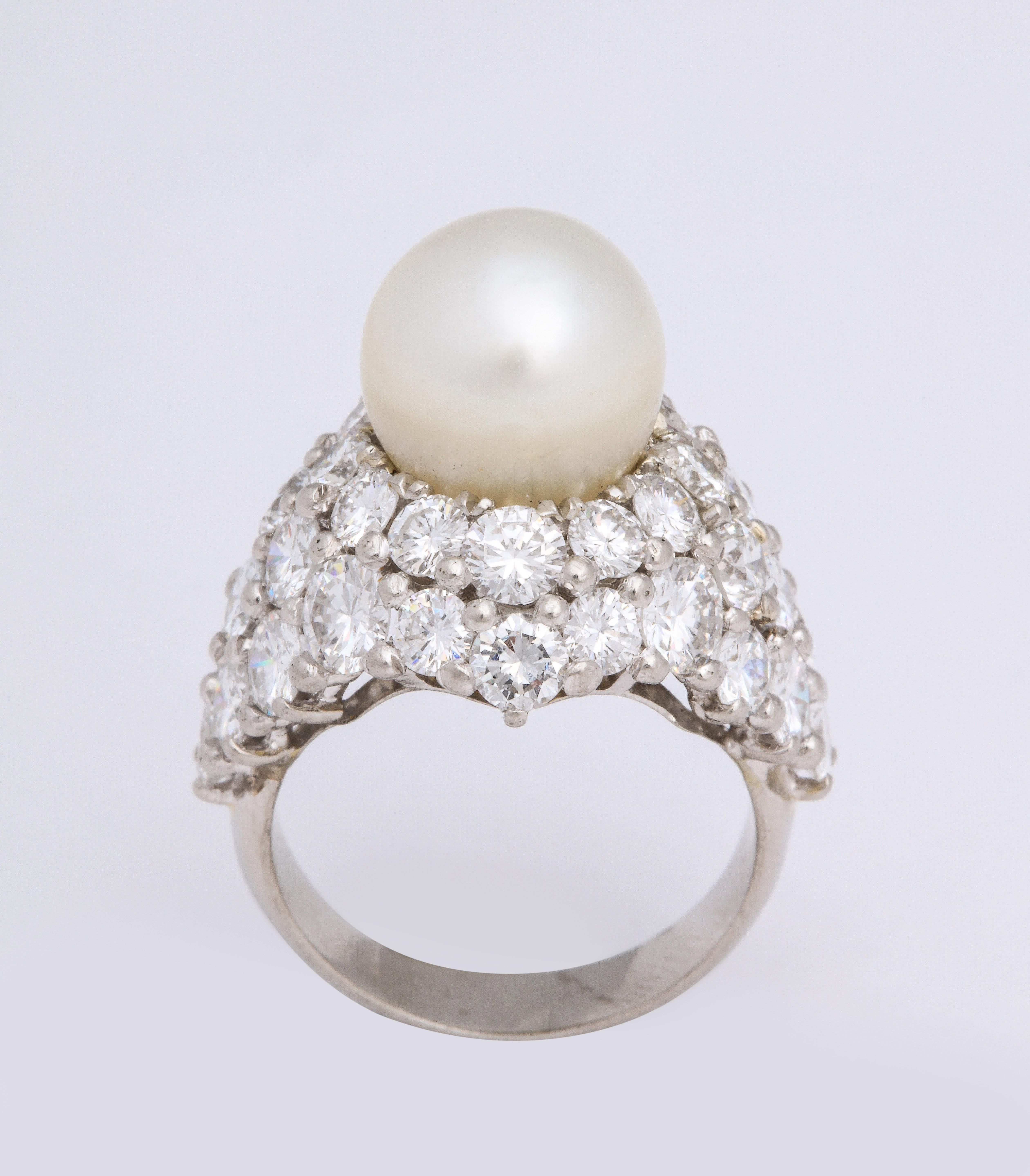 A bright and beautiful compact design of a classic platinum ring that features a gem-y, little natural pearl in a high domed diamond pave setting using the royal pave technique.  This pearl has is white with slight cream and pink undertones.  The