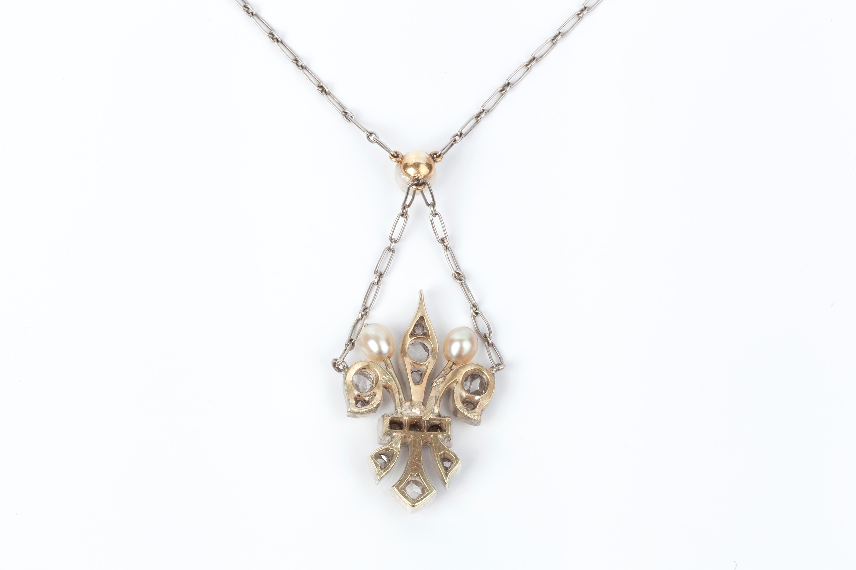 A natural pearl and rose cut diamond fleur-de-lis pendant on a platinum chain.  The chain length to the pearl is 16 inches with the drop  of the fleur-du-lis falling 2 inches further. 