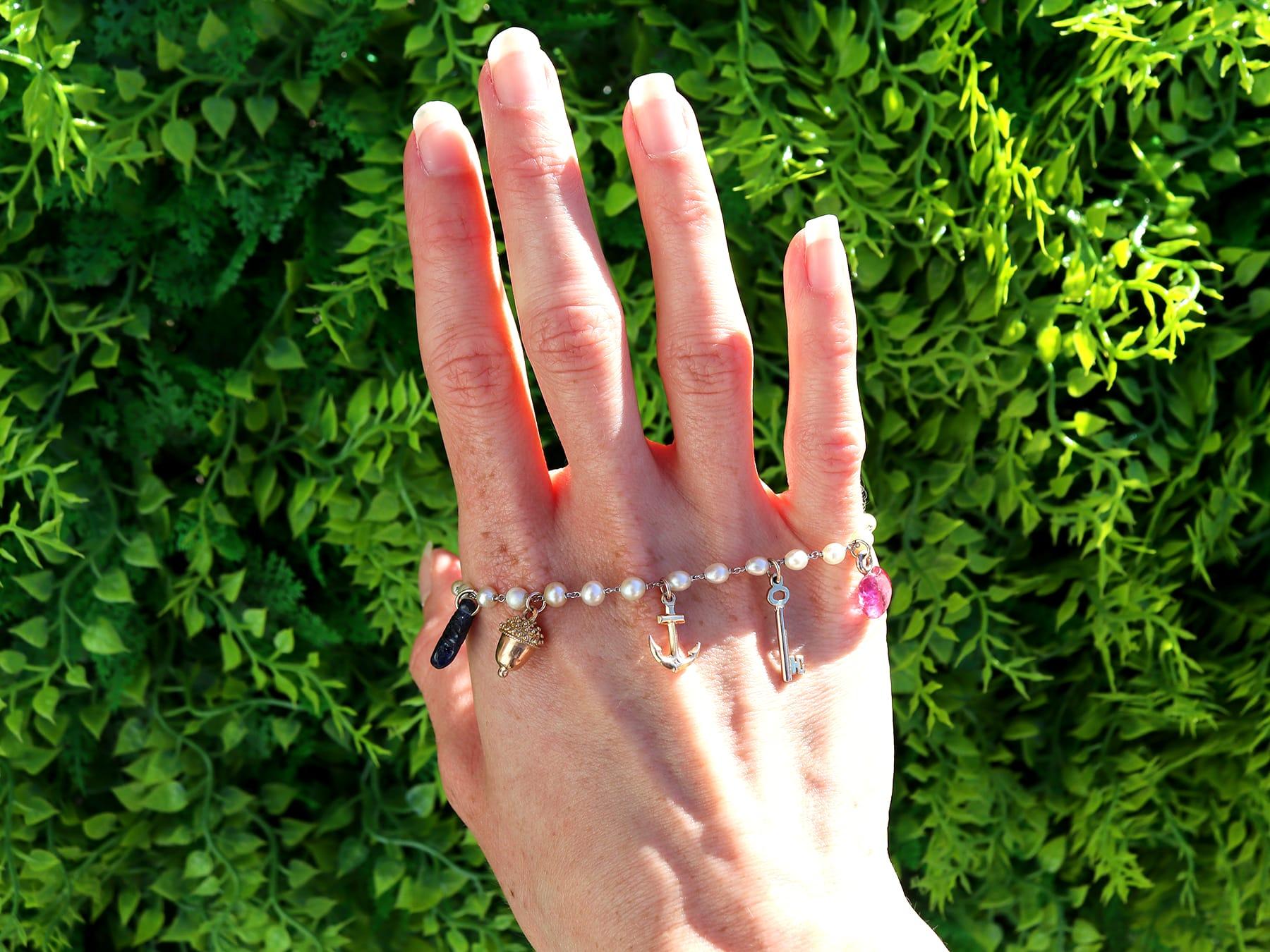Un bracelet à breloques exceptionnel, fin et impressionnant en perles naturelles et pierres précieuses, platine et or jaune 18 carats ; faisant partie de notre gamme variée de bracelets anciens.

Ce bracelet ancien, fin et impressionnant, a été
