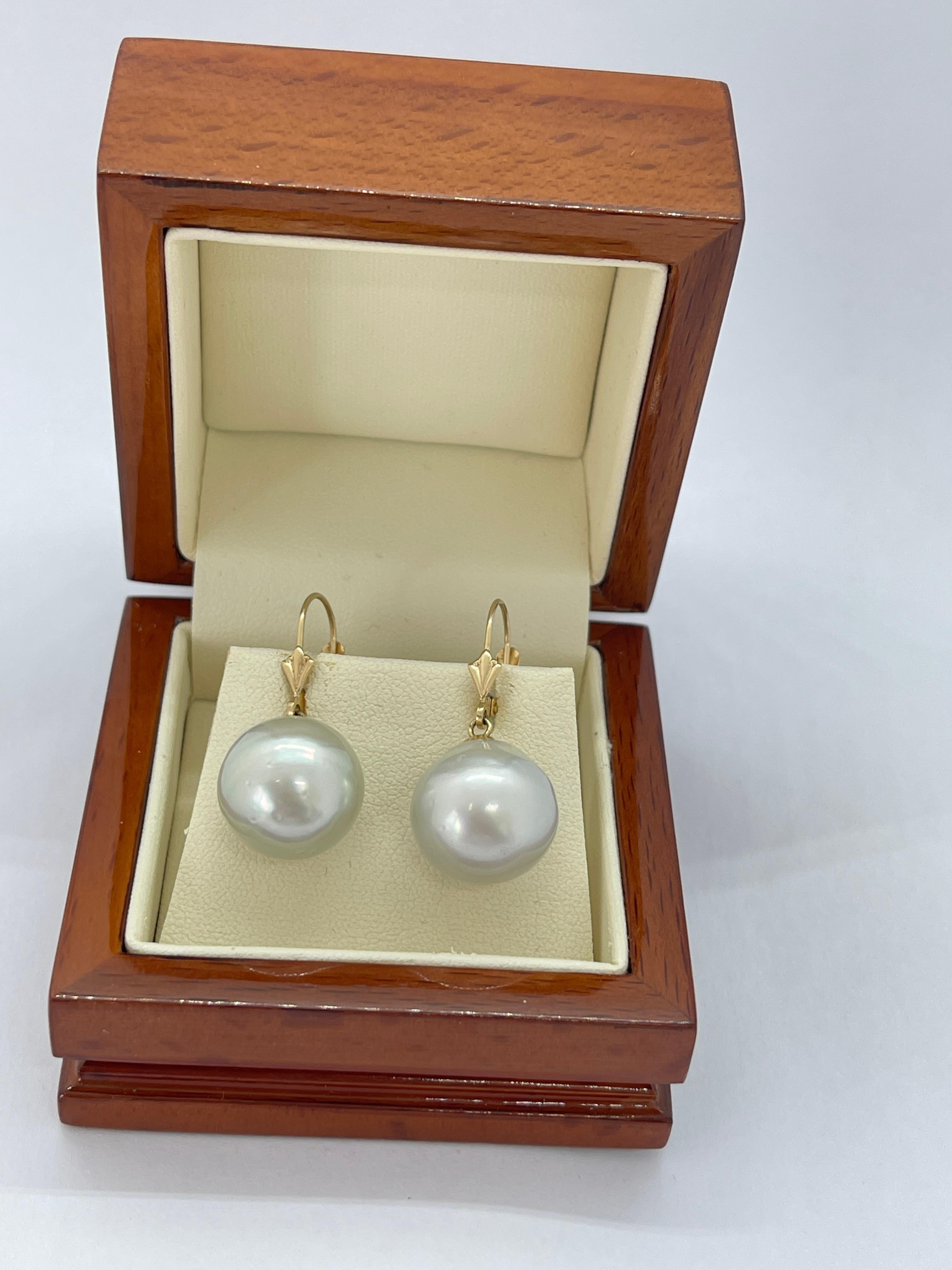 These lovely earrings are a staple for any jewellery collection.  They feature off round cultured pearls that display a silvery-grey hue.  The nacre and lustre are good, however there a some blemishes on each pearl.  One pearl has a small, brownish
