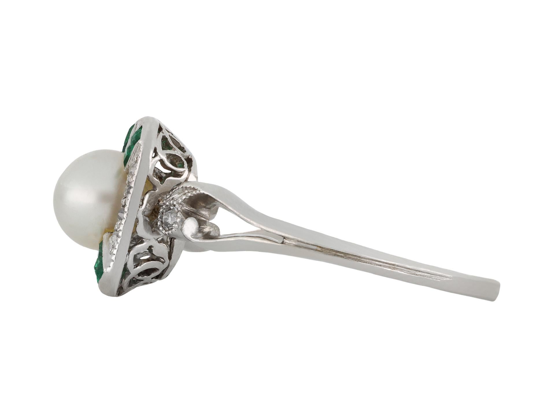 Anello con perle naturali, smeraldi e diamanti. Al centro è incastonata una perla naturale rotonda d'acqua salata in un'incastonatura chiusa a metà foro, delle dimensioni di circa 5,5 x 5,6 x 4,5 mm, decorata con otto smeraldi naturali taglio