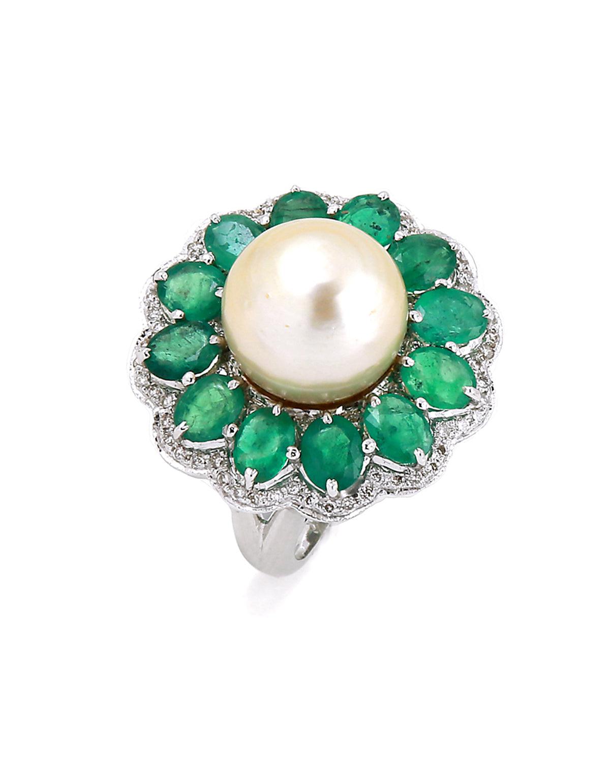Dieser schöne Ring ist aus 18 Karat Weißgold gefertigt und mit einer Perle in der Mitte und einem Smaragd besetzt. Der Ring ist außerdem mit Diamanten besetzt. Es ist ein schöner und einzigartiger Ring, der eine großartige Ergänzung für jede