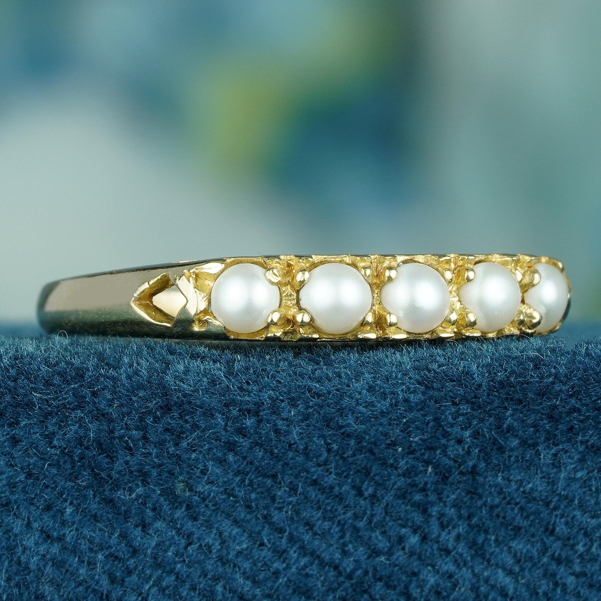 The ring showcases five round natural white pearls set in a solid yellow gold band, contributing to the vintage appeal of the piece. This classic and elegant jewelry is perfect for any occasion, offering versatility that allows it to be dressed up