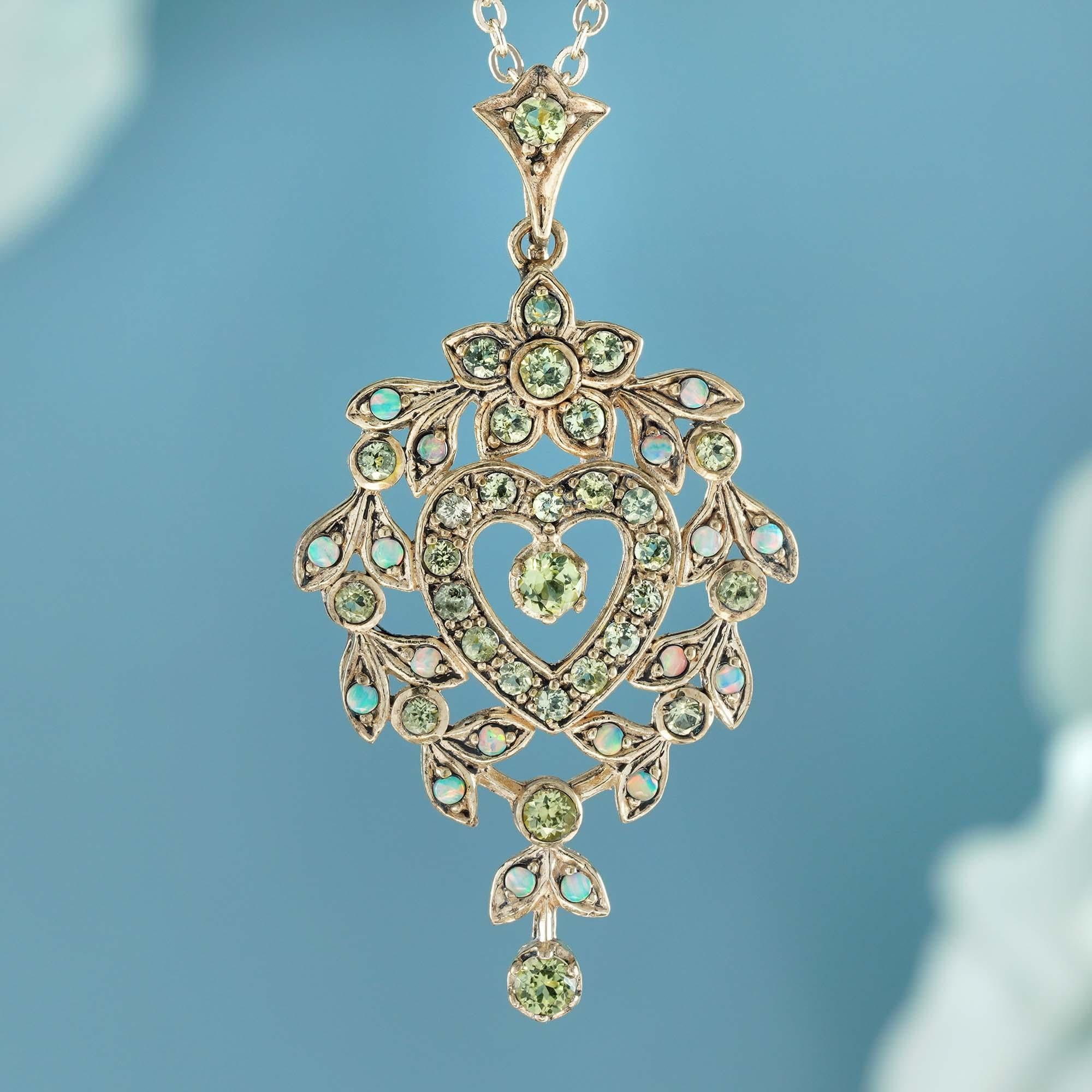The Victorian-style heart-shaped pendant with a floral motif. It’s set in solid yellow gold shines brightly features natural peridot and opal gemstones. The peridots are in the flowered and the heart frames at the center of the pendant, and they’re