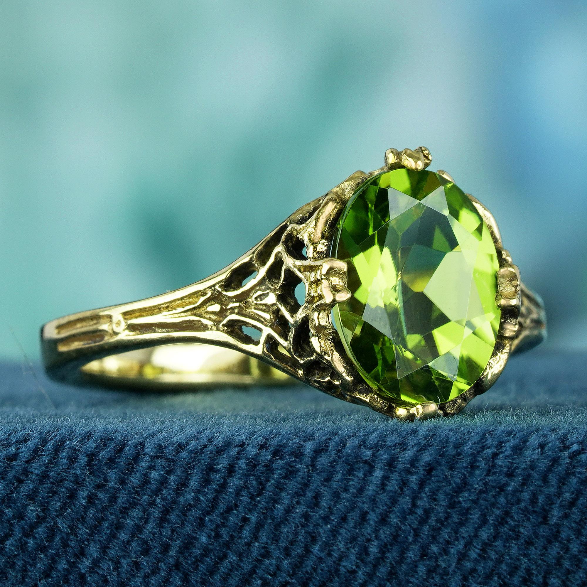 Crafted from luminous yellow gold, this ring boasts a wide band adorned with intricate filigree on the shoulders. The centerpiece of the ring is an oval lime green peridot gemstone, radiating with vibrant beauty and charm. Elevate your style whether