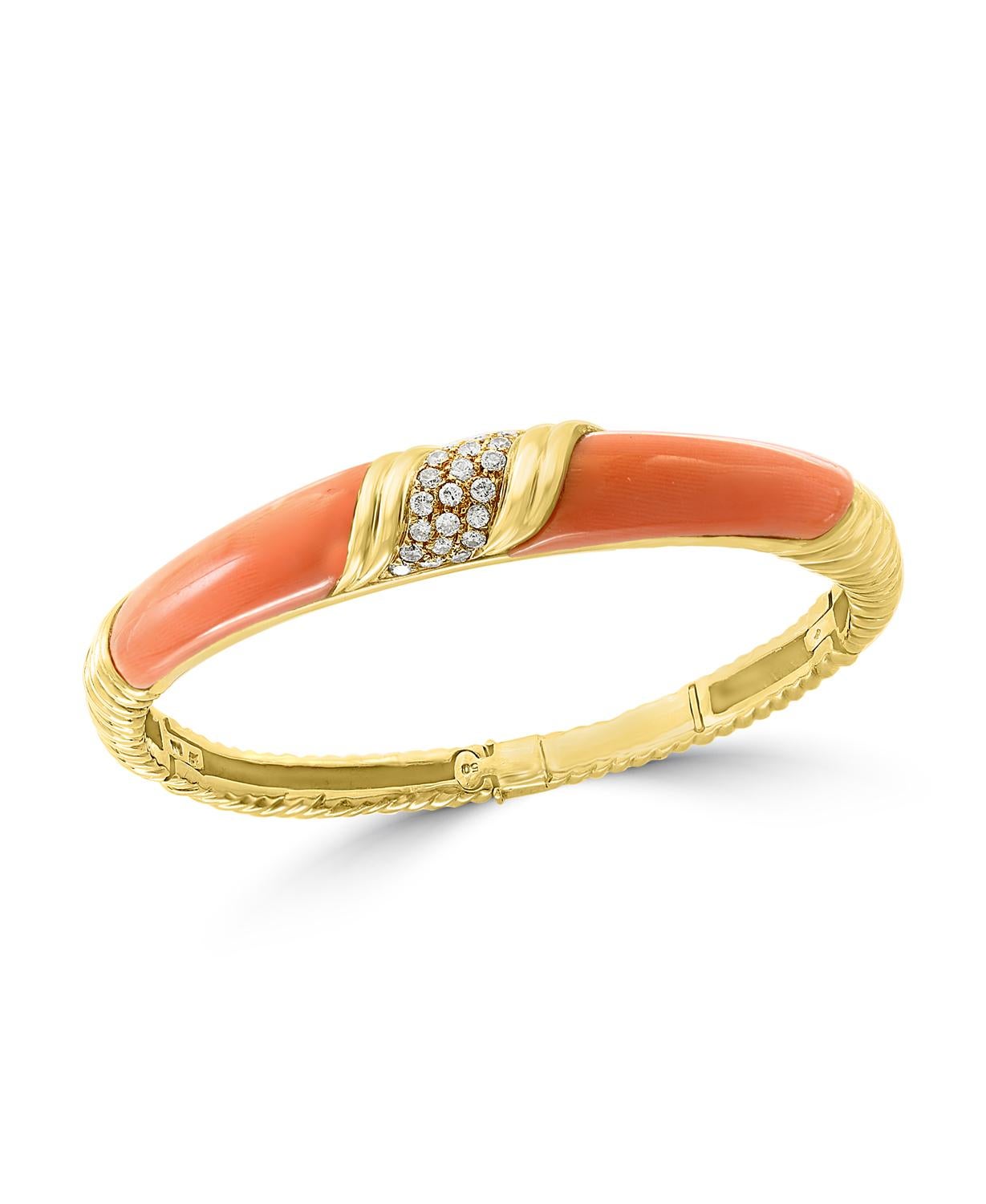  A spectacular jewelry piece.  This exceptional  and very reasonable in price Bangle bracelet 
 It has two large pieces of natural pink Coral and  approximately  0.80 ct. brilliant diamonds  
The  Bangle bracelet is expertly crafted with 23 grams of