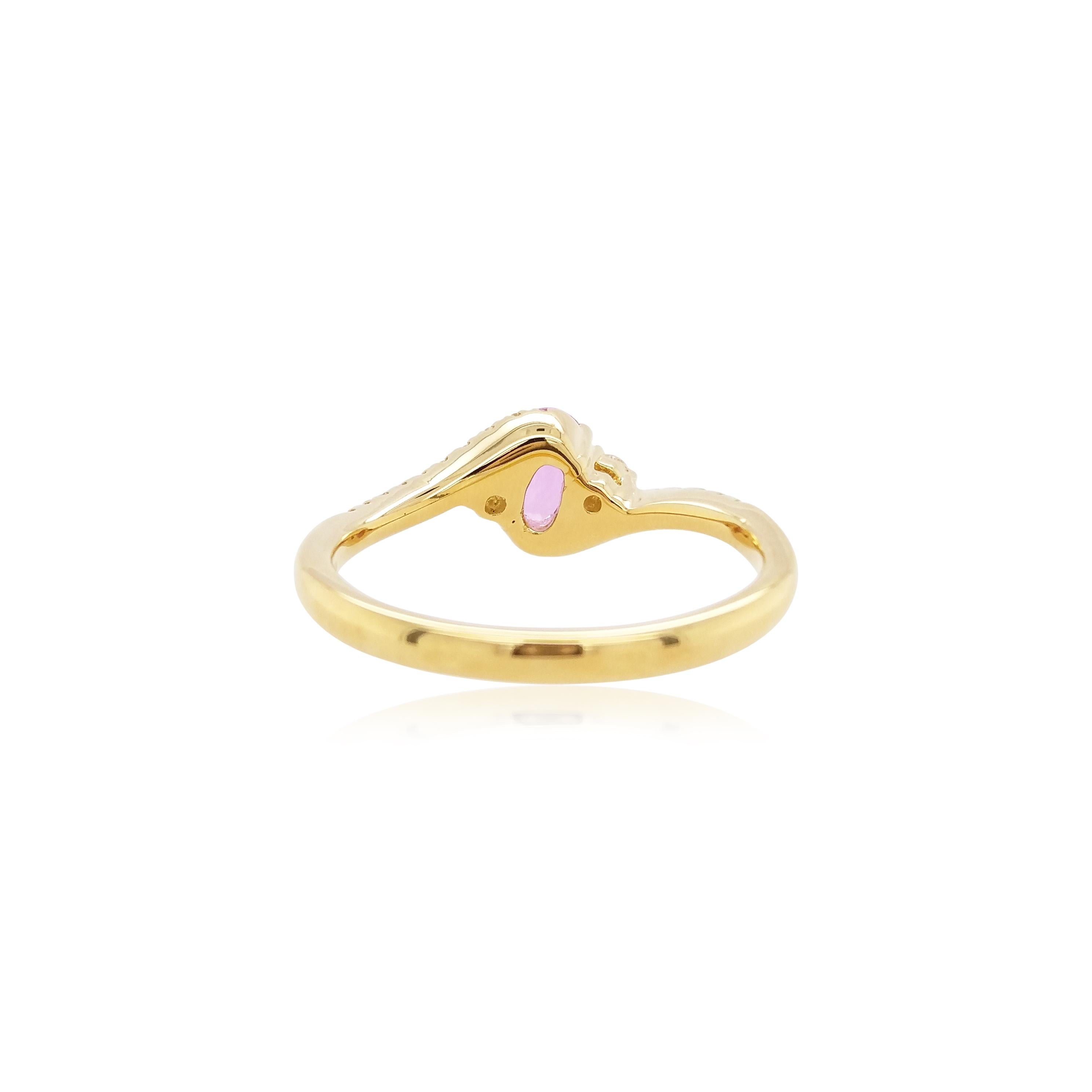 This delicate ring features a lustrous pink sapphire at the forefront of its design. The spectacular hues of the sapphire are perfectly accentuated by the 18 Karat Yellow Gold setting and elegant diamond shoulders. A versatile piece, this ring adds