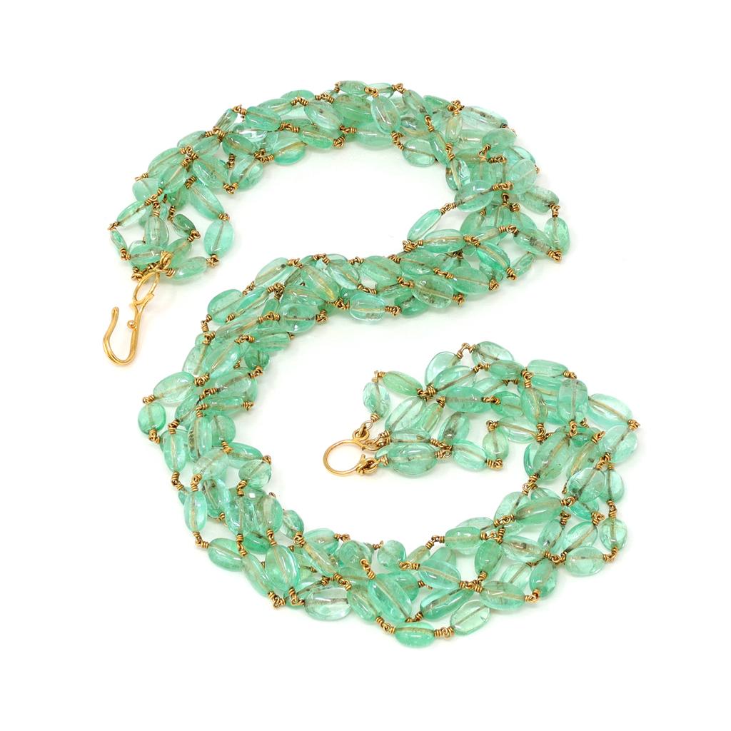 A handmade natural oval shape transparent emerald beads necklace. The four strands of well matched and polished natural emerald beads can be twisted to make the necklace shorter as desired. The emerald beads are strung together with 18 karat gold