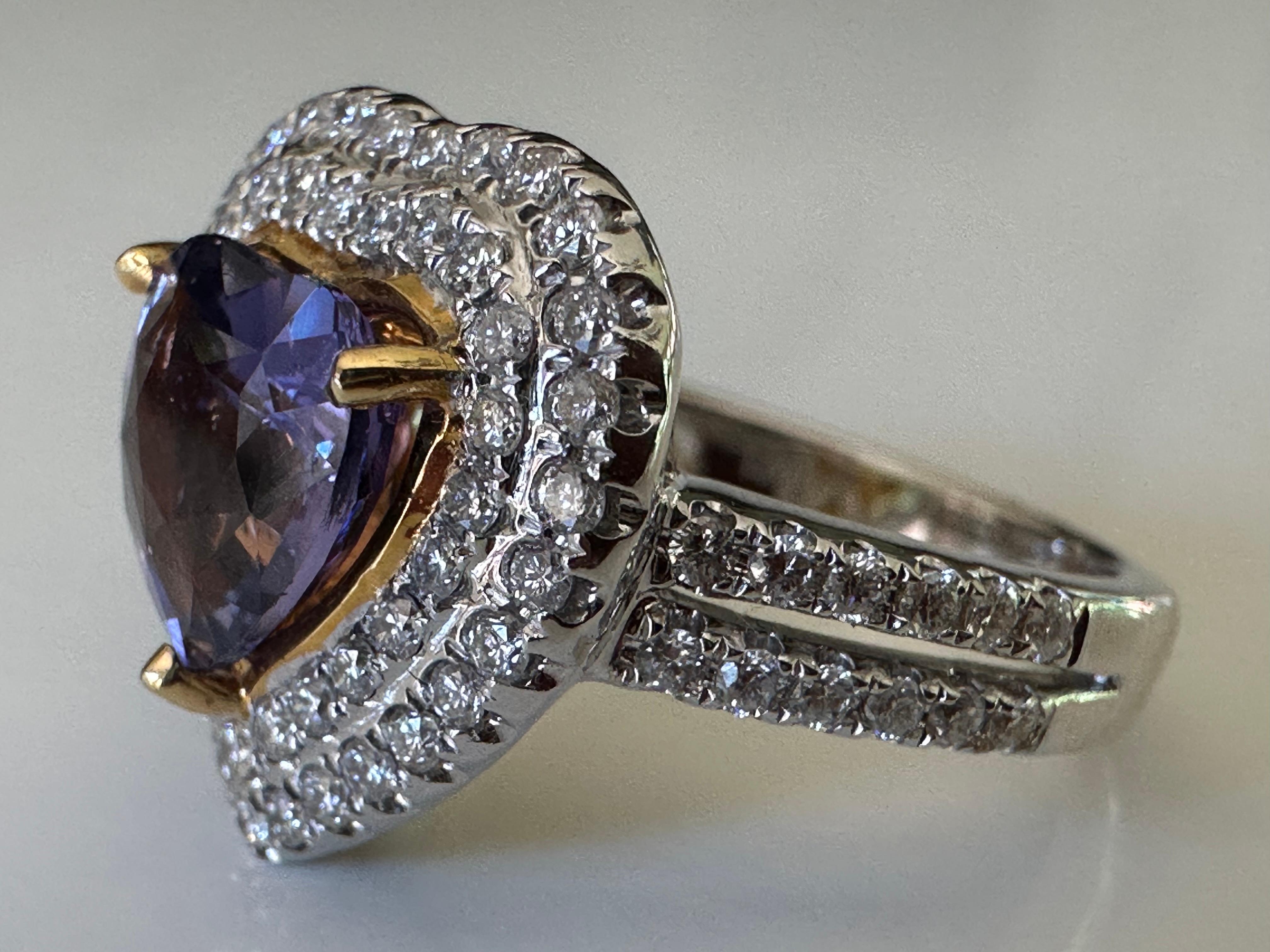 A 2.40-carat natural purple heart-shaped sapphire from Madagascar centers this exquisite ring surrounded by a double halo of seventy-six round brilliant-cut diamonds totaling 0.71 carats. Set in 18K white and yellow gold. 
