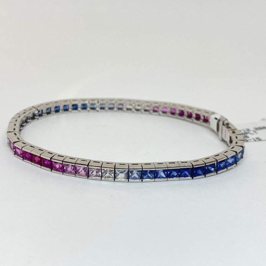 Schönes Tennisarmband mit natürlichem Regenbogensaphir aus Platin. Das Armband enthält 55 mehrfarbige Saphire (tiefrosa, eisblau und weiß) im quadratischen Prinzessschliff mit einem Gesamtgewicht von 12,20 Karat. Das Armband ist 4 mm breit und 7