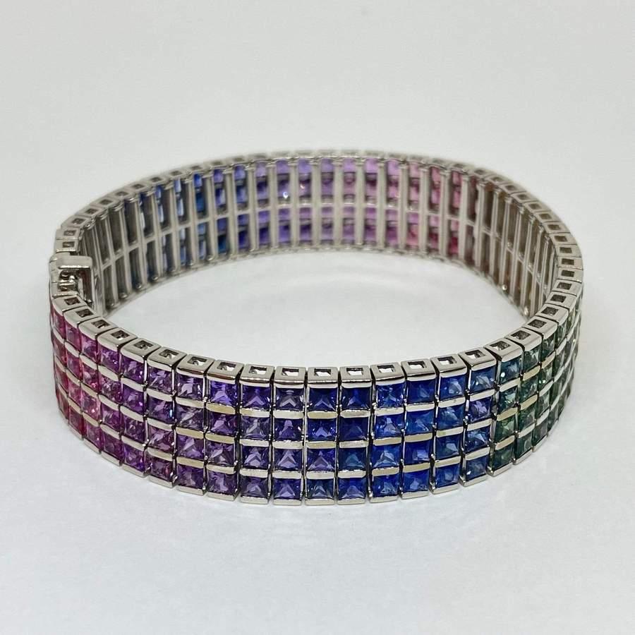 Beautiful natural rainbow sapphire tennis bracelet designed in 18 karat white gold. The bracelet contains 232 multi color sapphires (all colors of the rainbow) princess square cut, 4-row channel set, with a total weight of 35 carats! The bracelet