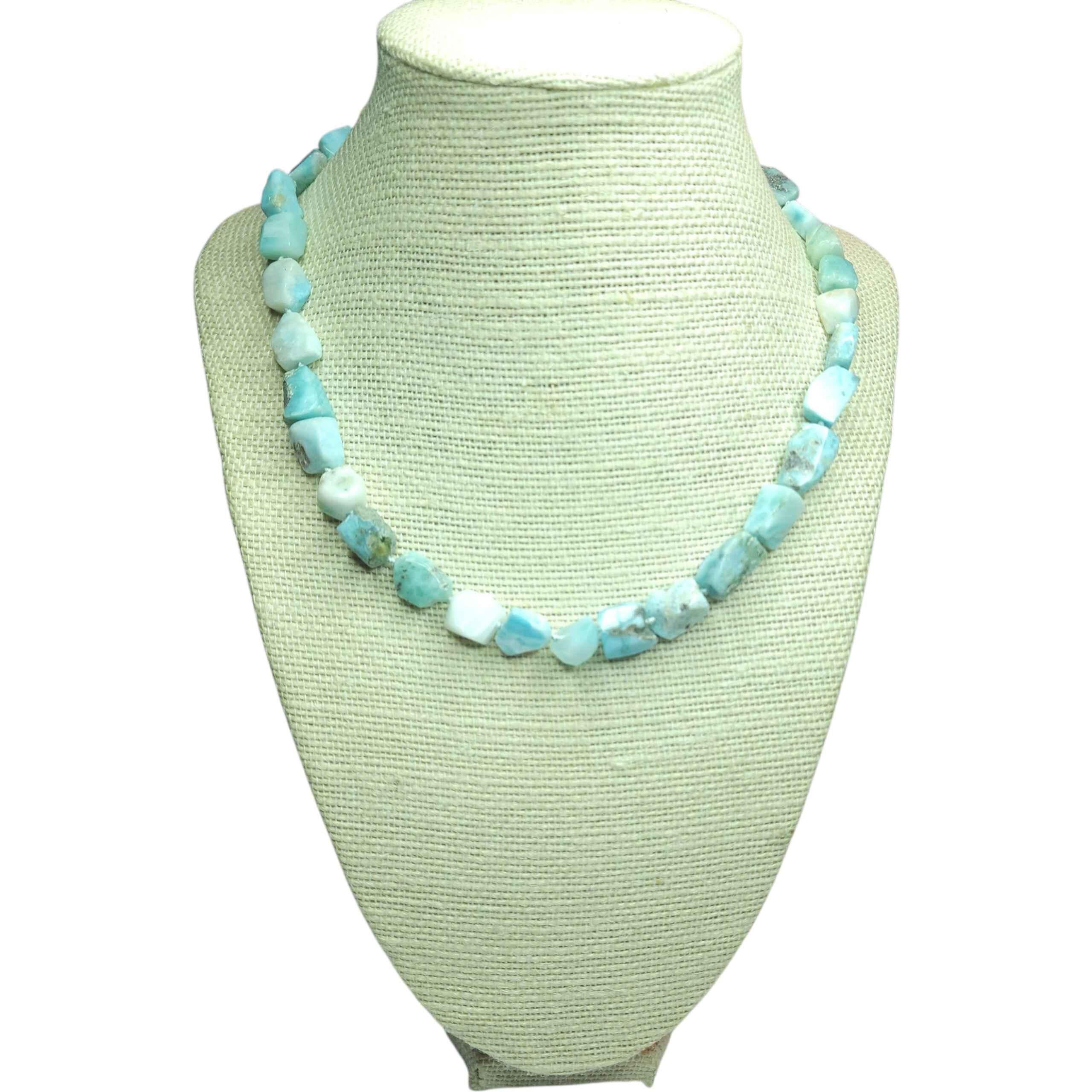 Una straordinaria collana artigianale composta da pepite di larimar naturale grezzo, ogni pietra tagliata e lucidata singolarmente solo per preservarne la geometria organica. La tavolozza si muove tra morbidi blu caraibici, verdi marini, bianchi