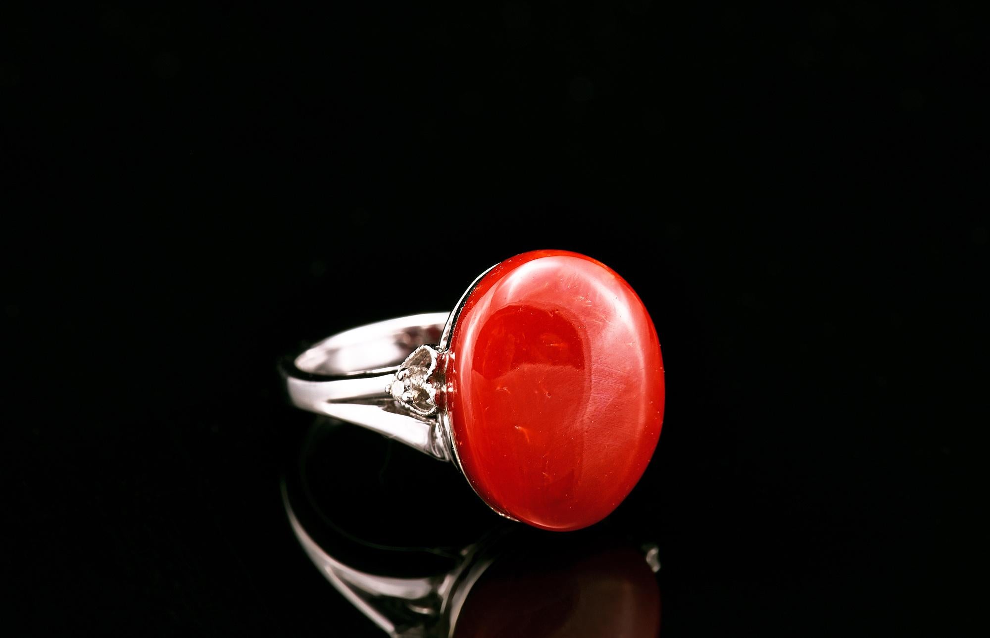Este elegante anillo exhibe una pieza central de coral rojo natural 