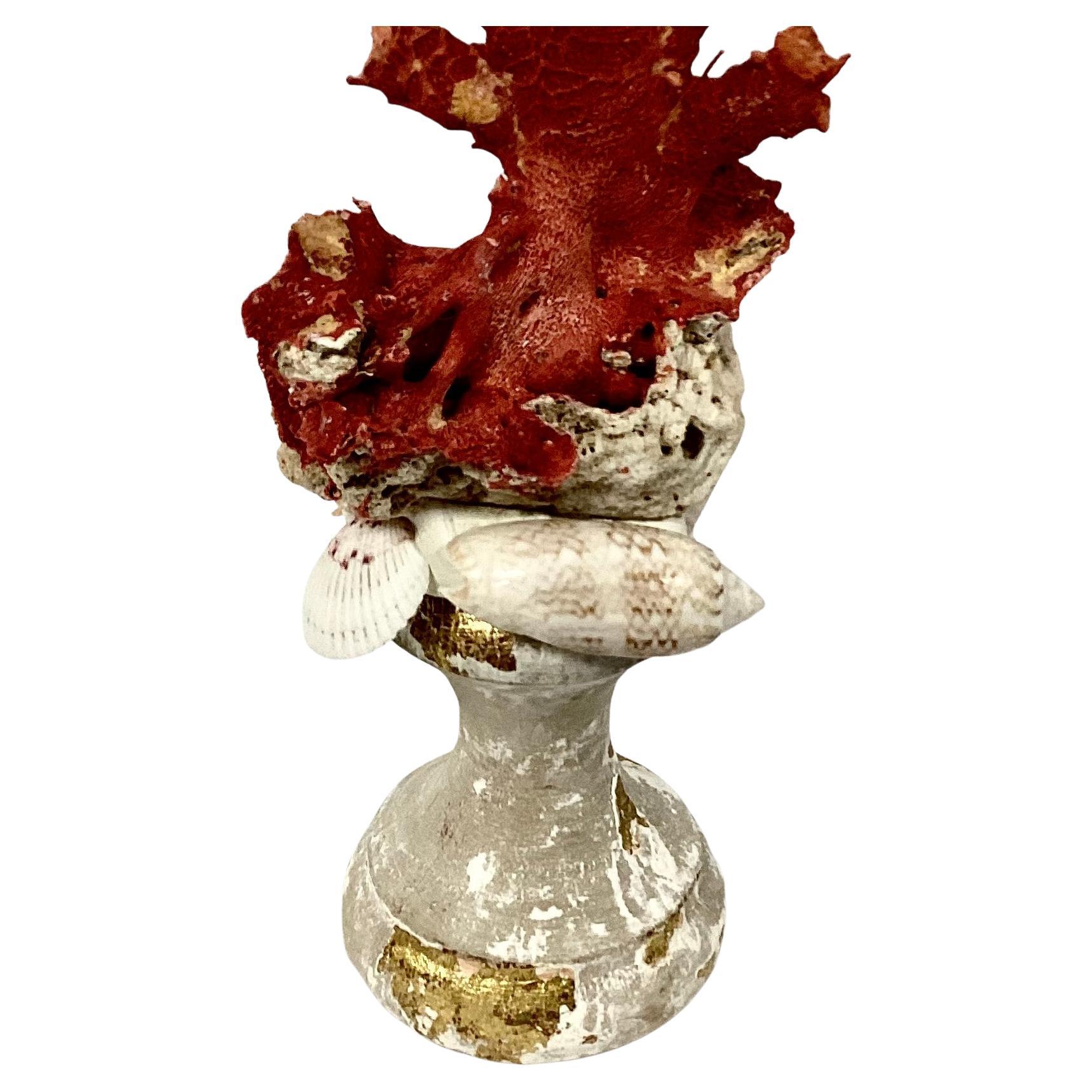 A hand-crafted sculpture specimen of natural red coral branches mounted on a 18th century giltwood urn fragment base with sea shell trim.
