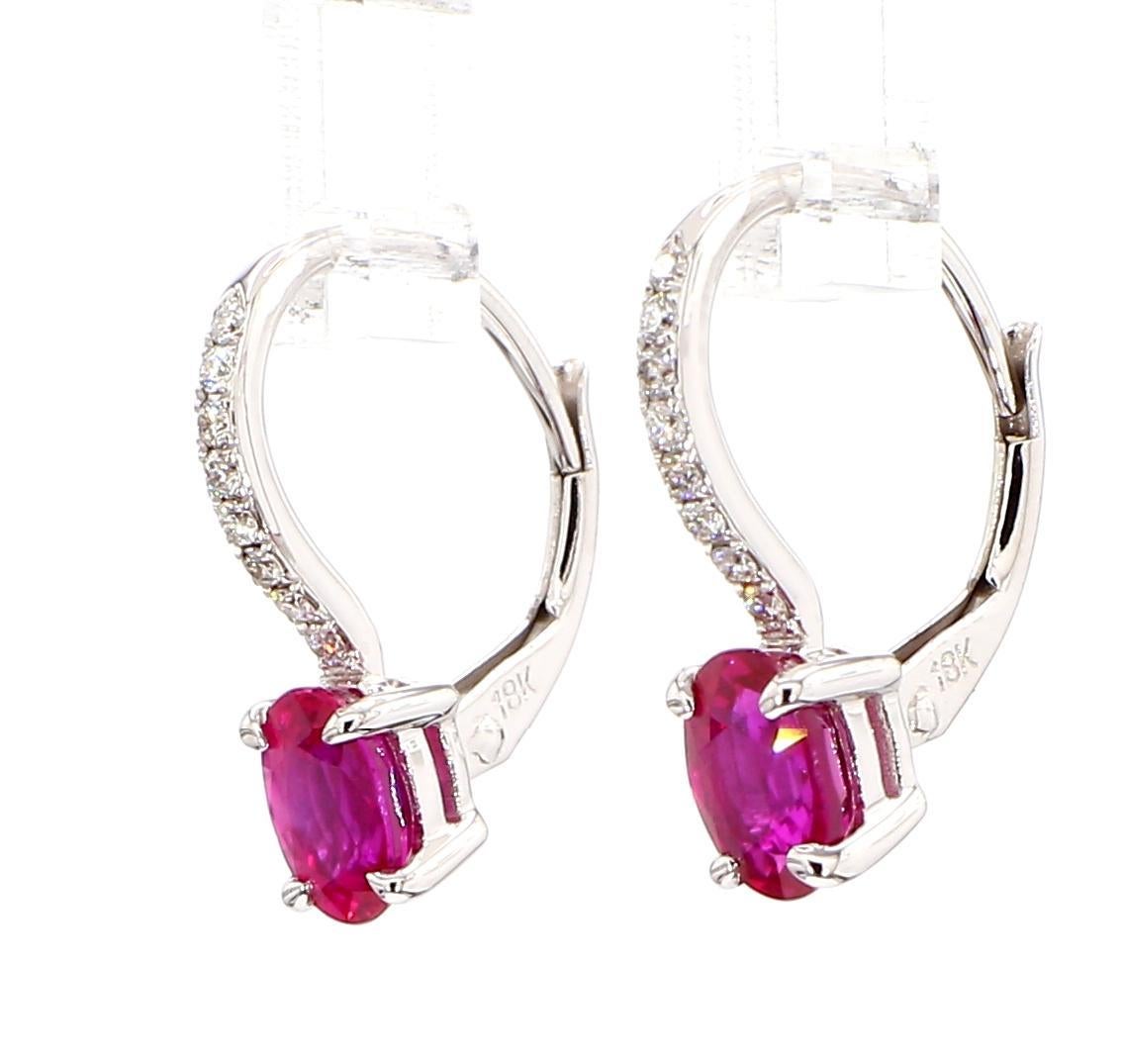 Boucles d'oreilles classiques en rubis de Raregemworld. Monté dans une magnifique monture en or rose et blanc 18 carats avec des rubis rouges naturels de taille ovale complétés par des diamants blancs ronds naturels. Ces boucles d'oreilles sont