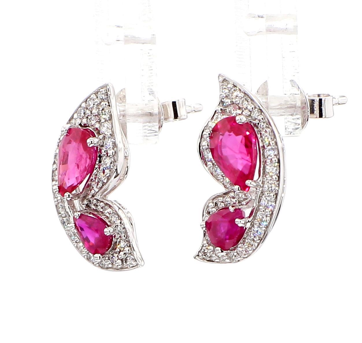 Boucles d'oreilles intrigantes en rubis de Raregemworld. Monté dans une belle monture en or blanc 14K avec des rubis rouges naturels taillés en poire, complétés par une mêlée de diamants blancs ronds naturels. Ces boucles d'oreilles sont garanties