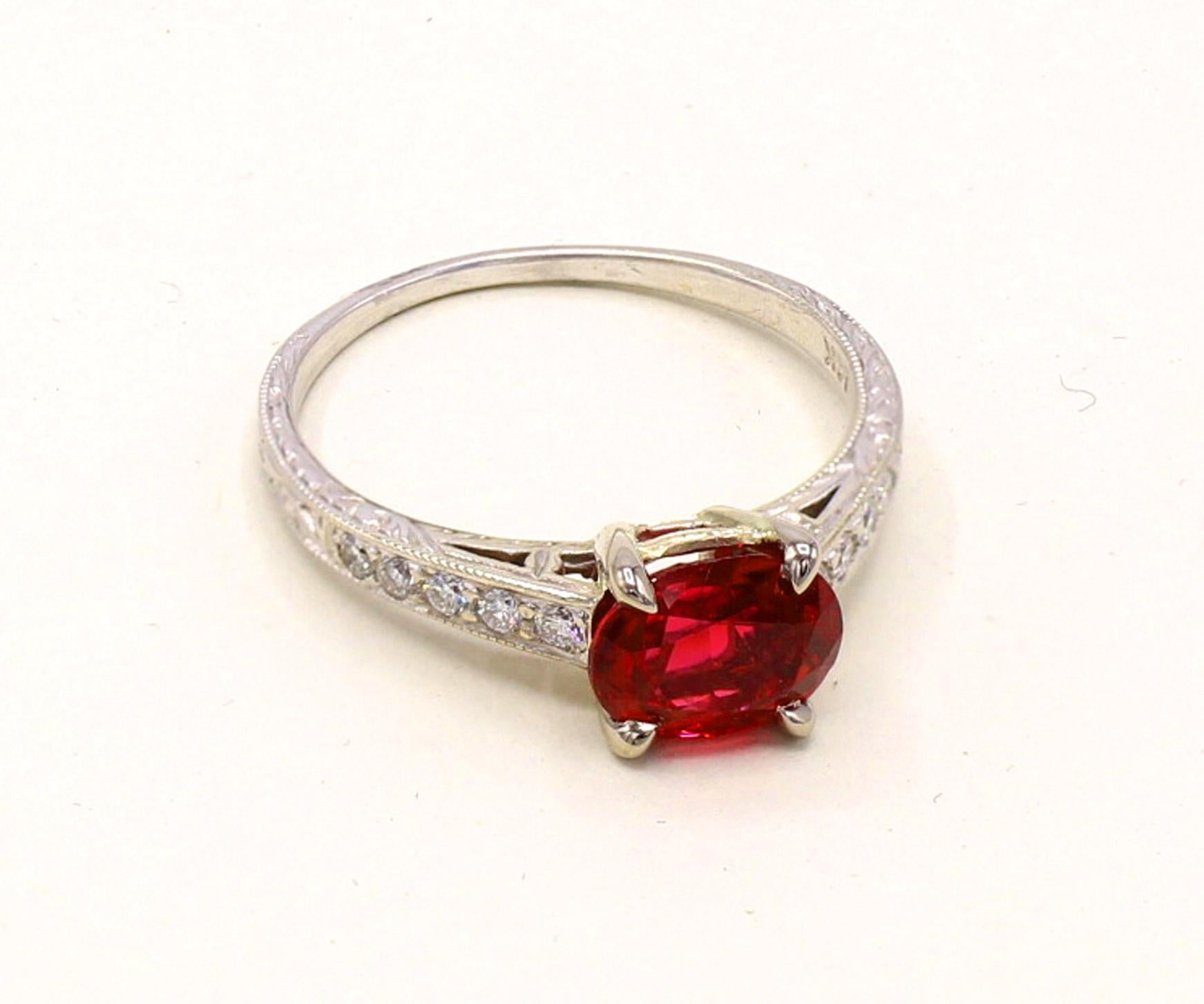 A beautifully cut oval intense red spinel weighing 1.40 carats is the centerpiece of this lovely engagement ring. The red spinel has an amazing saturation of color, brilliance , life and fire. This gem is accompanied by a report from the AGL stating