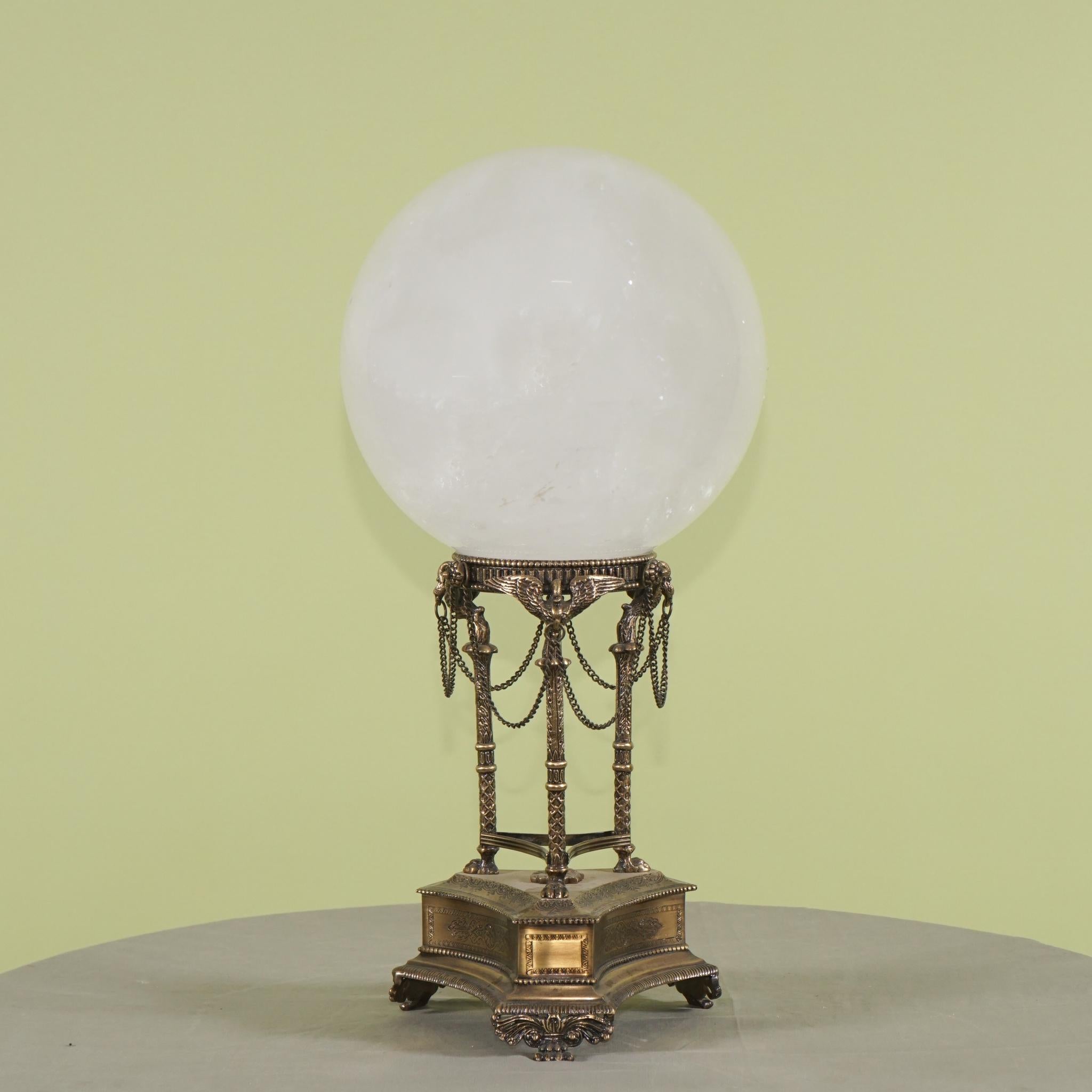 This natural rock crystal sphere containing expected color changes and inclusions is a gem from nature. The sphere is 9 inches in diameter and runs from clear to crazed inclusions throughout. The stand is cast in bronze to a classical ideal then