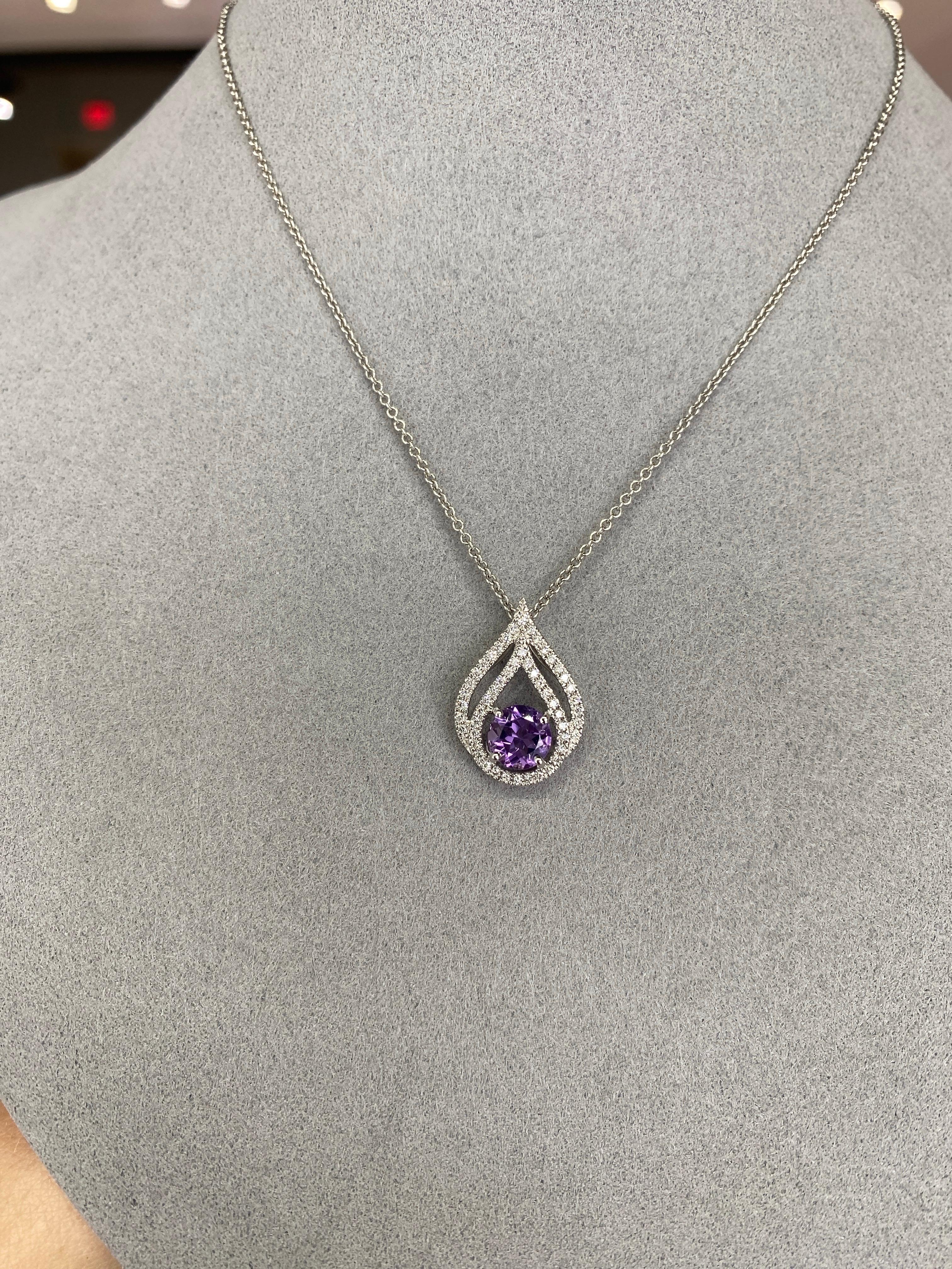 Ce pendentif exquis présente une captivante améthyste ronde naturelle de 0,74ct, complétée par d'éblouissants diamants ronds naturels de 0,25ct en forme de goutte d'eau, le tout élégamment serti dans un luxueux or blanc 18 carats. Parfait pour