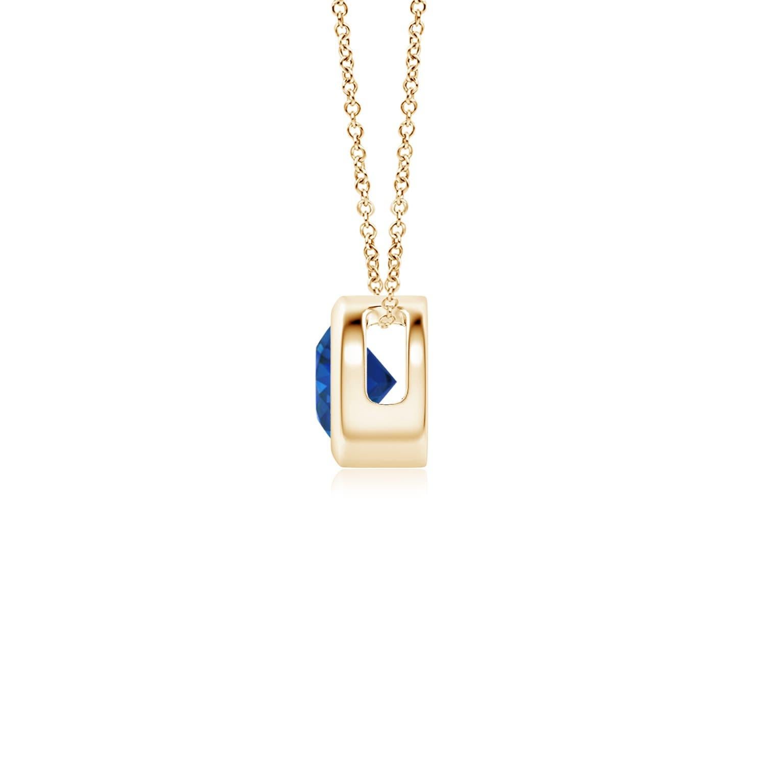 Le magnifique design de ce pendentif solitaire classique en saphir donne l'impression que la pierre centrale flotte sur la chaîne. La pierre précieuse d'un bleu éclatant est fixée dans une monture à chaton. Réalisé en or jaune 14k, ce pendentif en