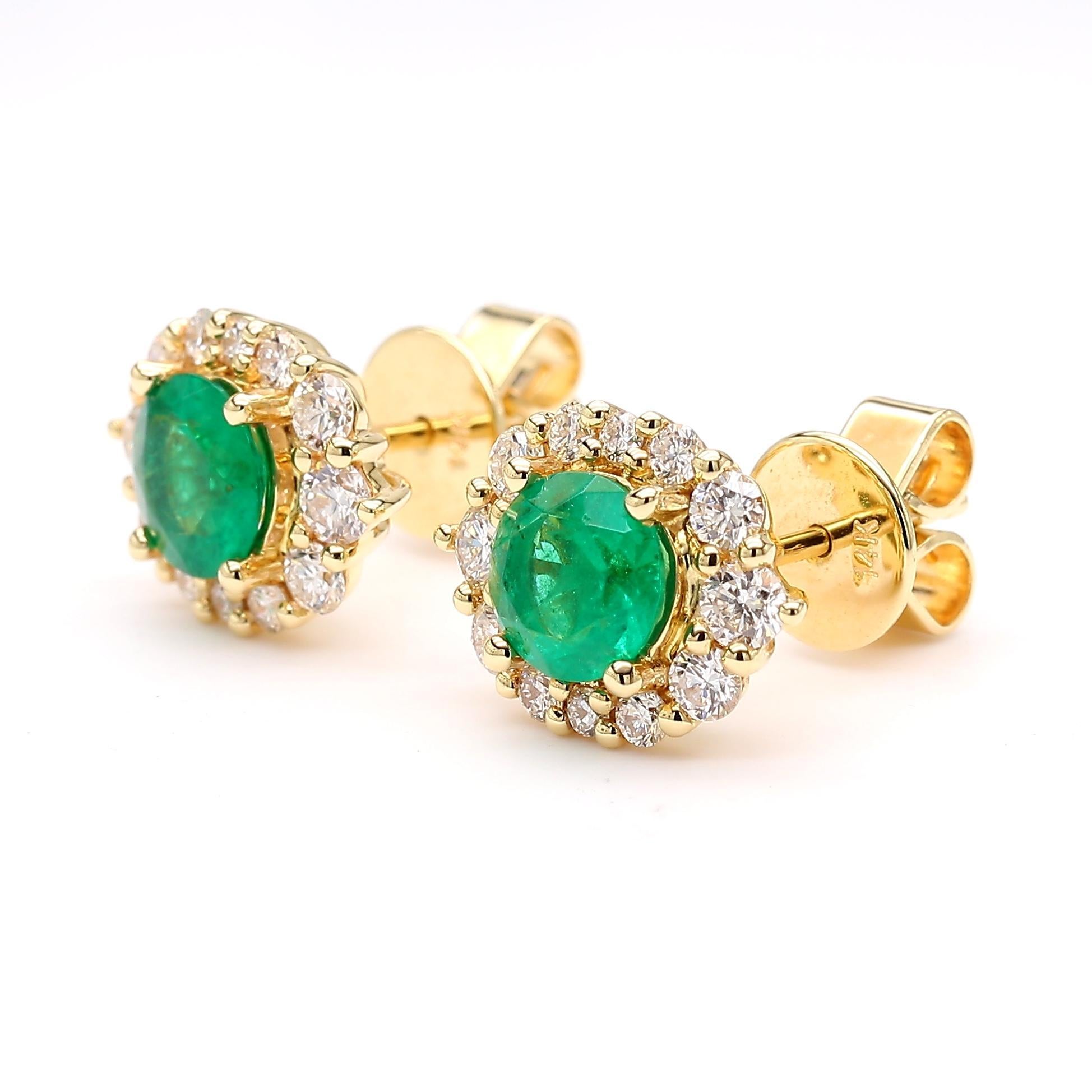 RareGemWorld's classic emerald earrings. Mounted in a beautiful 14K Yellow Gold setting with natural round cut green emerald's. The emerald's are surrounded by natural round white diamond melee. These earrings are guaranteed to impress and enhance