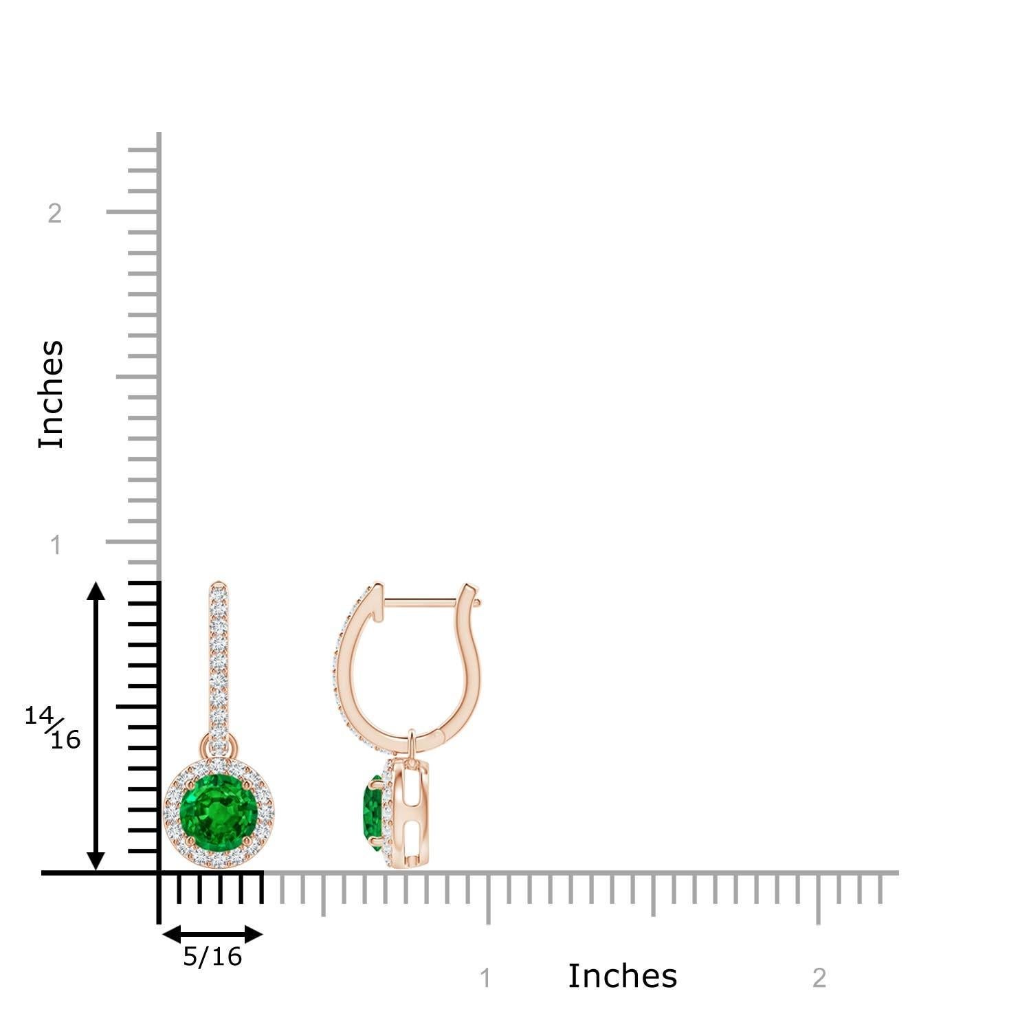 Des émeraudes rondes d'un vert luxuriant sont nichées dans un halo scintillant de diamants ronds en serti clos. Les accents de diamant sur l'anneau confèrent une touche d'élégance supplémentaire à ces boucles d'oreilles pendantes en émeraude