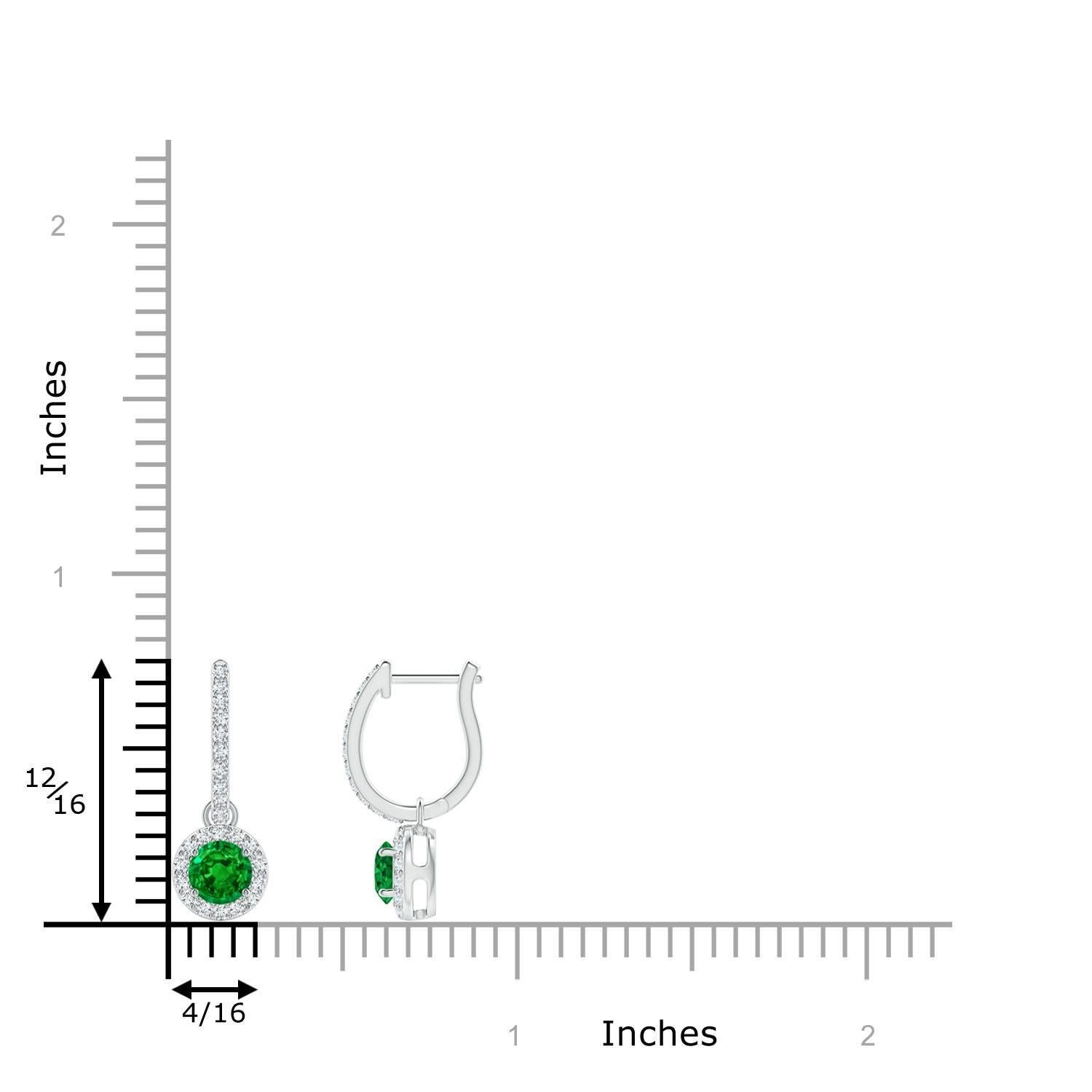 Des émeraudes rondes d'un vert luxuriant sont nichées dans un halo scintillant de diamants ronds en serti clos. Les accents de diamant sur l'anneau confèrent une touche d'élégance supplémentaire à ces boucles d'oreilles pendantes en émeraude