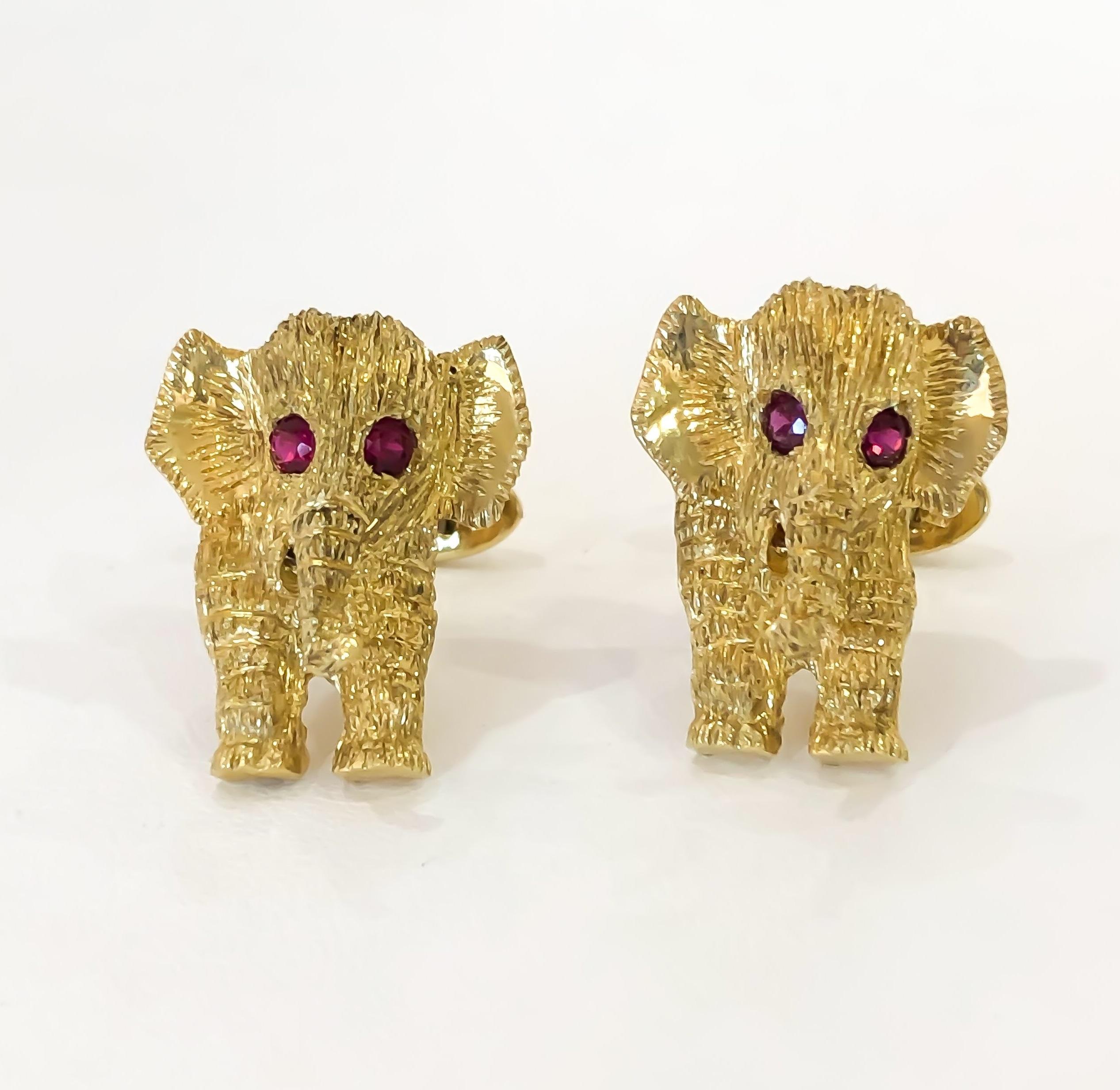 Exotic estate pre-owned men's Elephant and Ruby cufflinks designed in 18 karat yellow gold. Elephant heads, two front legs, trunk and ears are engraved and textured. Natural faceted rubies are bead set for the Elephants eyes. Stamped 