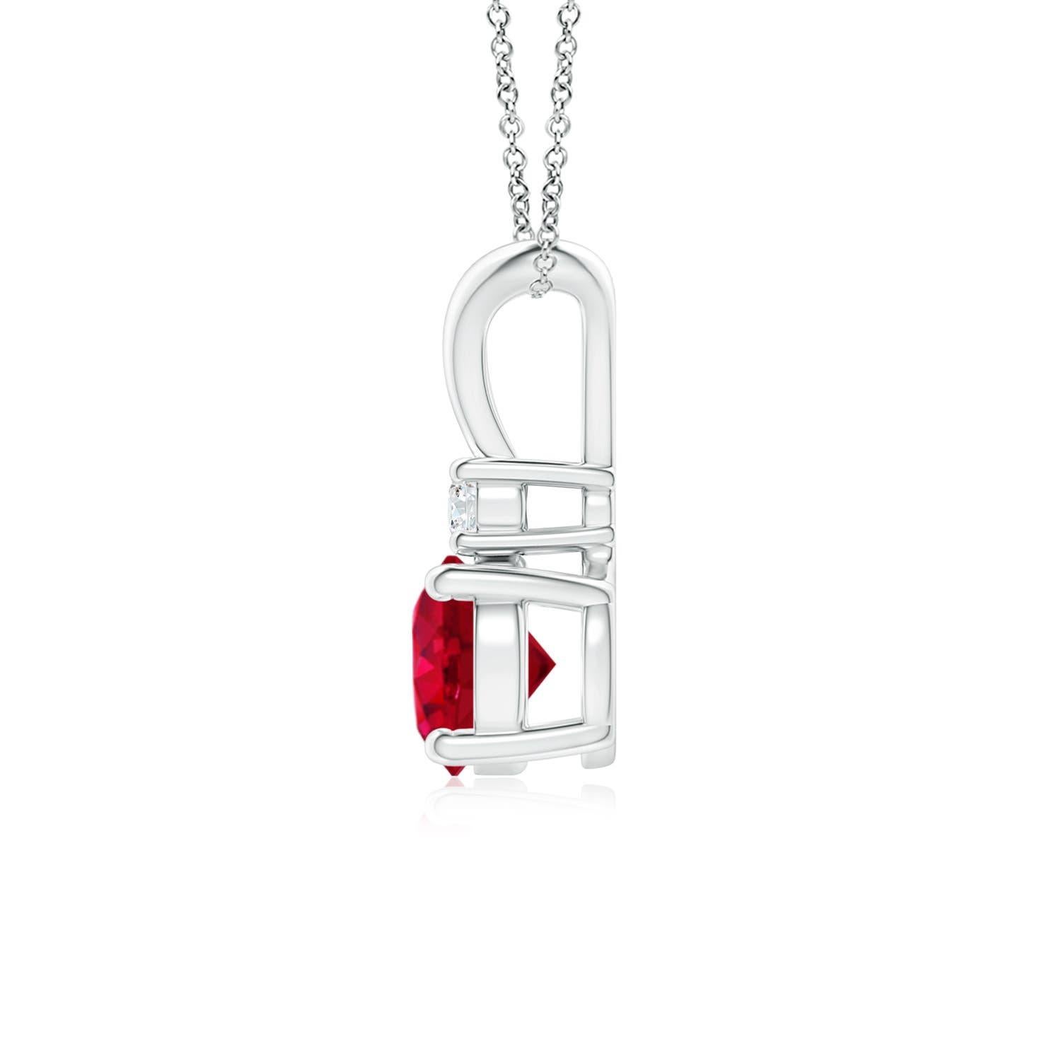 This four-prong set ruby pendant displays the perfect blend of style and beauty. A lustrous diamond on top of the purplish red gemstone enhances its charm. This classic solitaire ruby pendant with a polished v-bale is artfully designed in