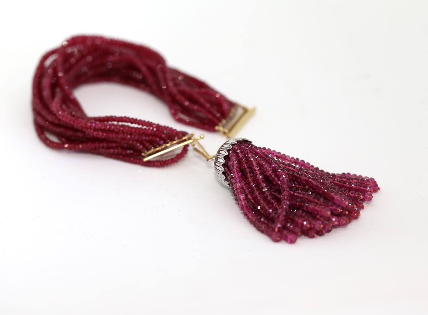 Bracelet de perles de rubis avec fermoir en or et pendentif amovible de perles de rubis supplémentaires avec un dôme en platine. 

Pendentif Rubis Perles Or Platine. Créée vers 1920. Pendentif en platine avec des perles de rubis. 
Le pendentif se