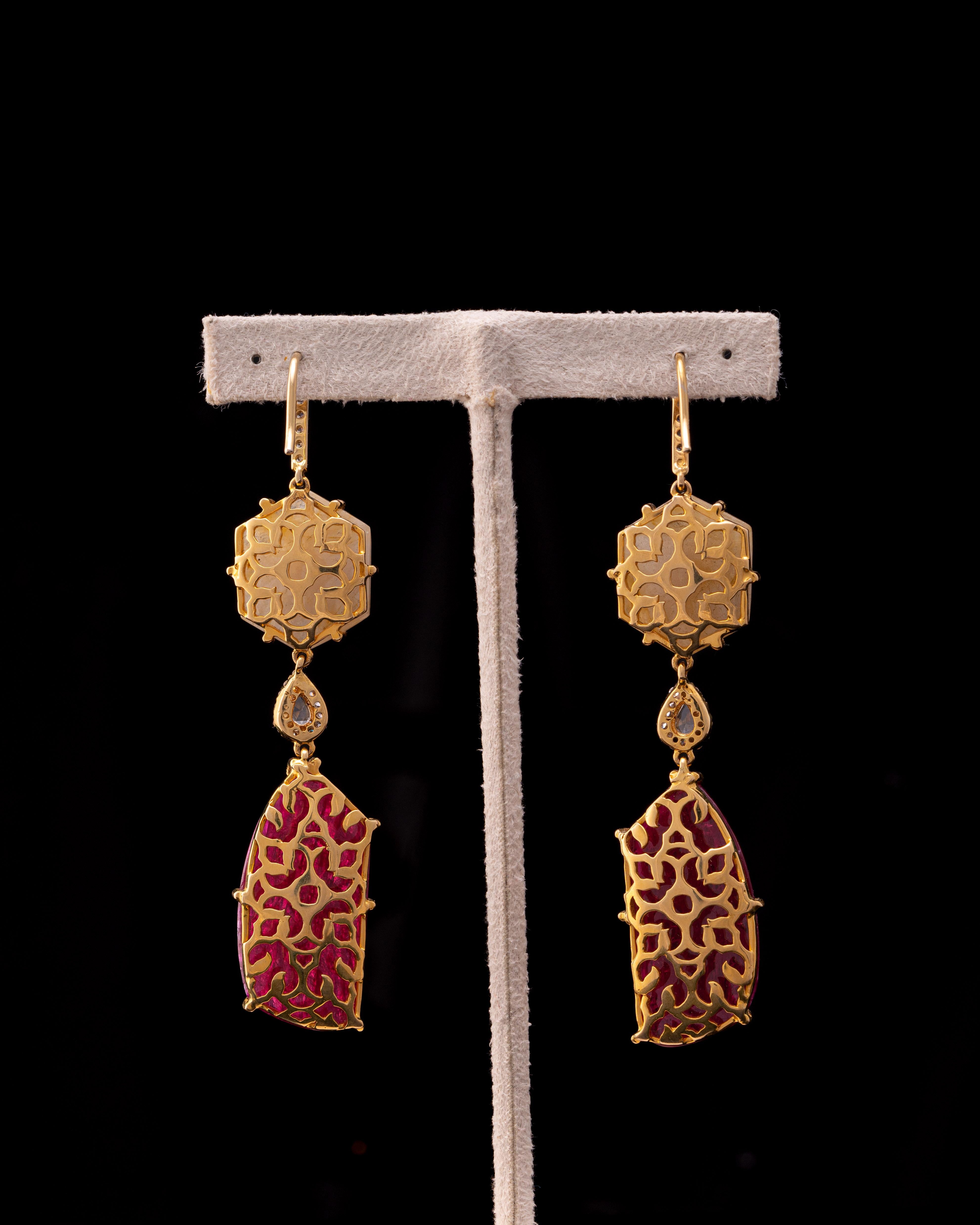 A pair of art-deco looking, 27.39 carat natural Ruby and 15.70 carat Yellow Sapphire dangle earrings, with 0.28 carat White Diamonds, all set in solid 18 K Yellow Gold. 
Please message us for more information. 
We provide free shipping, and accept