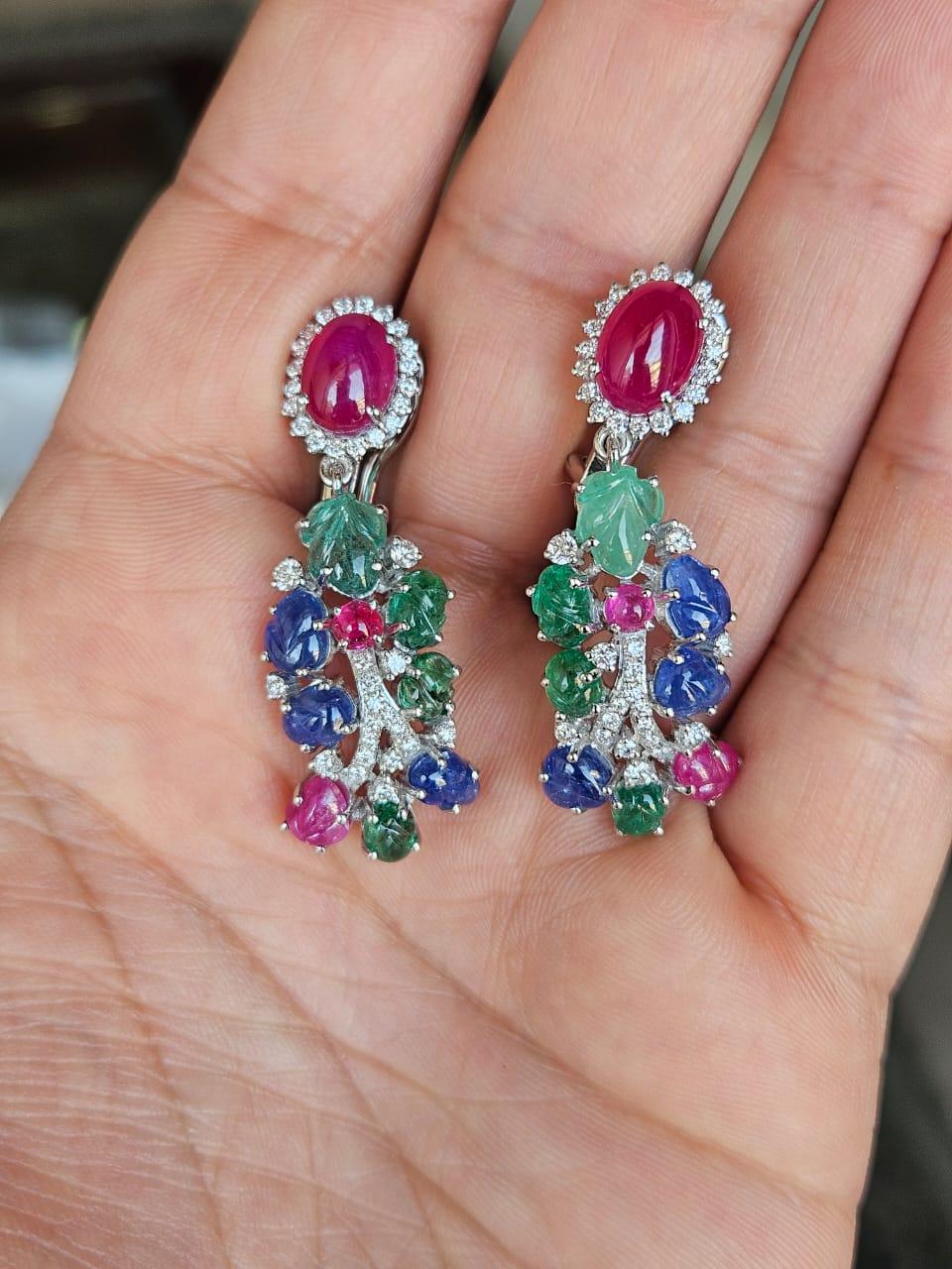 Preciosos pendientes de araña de estilo clásico con rubíes, esmeraldas y zafiros azules, engastados en oro blanco de 18 quilates y diamantes naturales. El peso combinado de los cabujones de Rubí, los Zafiros Azules tallados, las Esmeraldas talladas