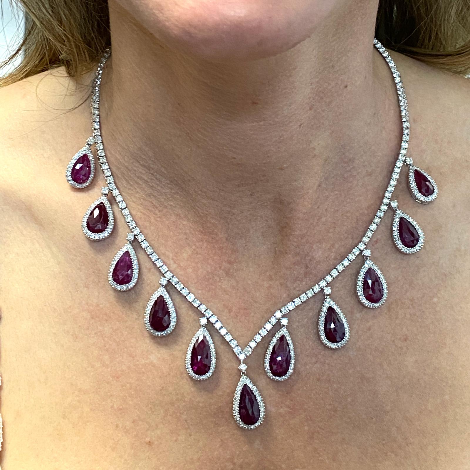 Beautiful diamond and natural ruby drop necklace fashioned in 18 karat white gold. The 11 pear shape natural rubies weigh approximately 11.00 carat total weight, and are heat treated. The round brilliant cut diamonds weigh approximately 12.00 carat