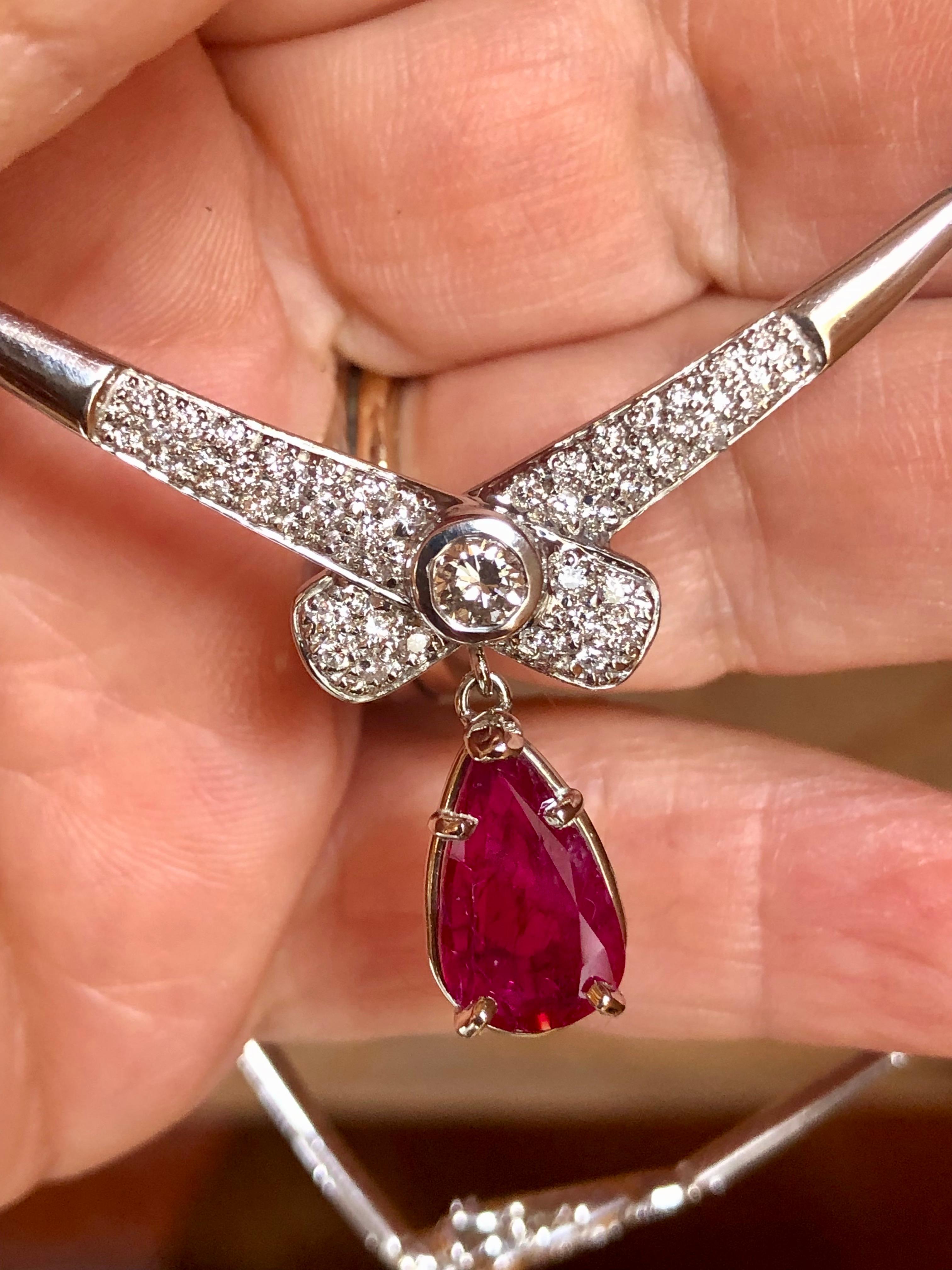 ESTATE Necklace Featuring in the Center a Pear Cut Mozambique Natural Ruby Weighing 2.30 carats, Not Treated. The ruby is set in a beautiful vintage-inspired scroll setting. The center bow design of the necklace features a round brilliant cut
