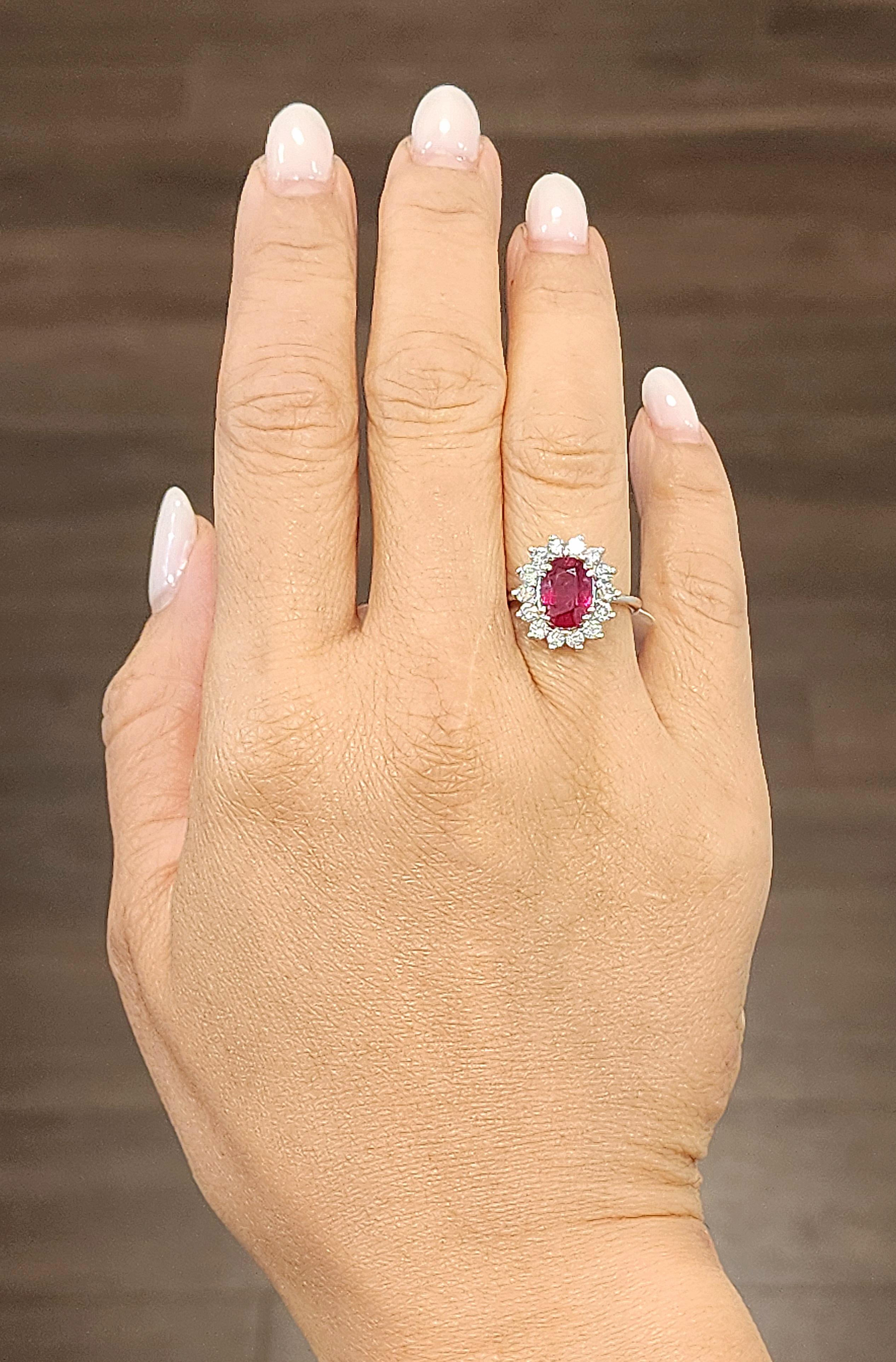 Un superbe rubis naturel de 2,05 carats est délicatement rehaussé d'un halo de 0,60 carats de diamants ronds de taille brillant, créant un spectacle époustouflant de couleurs et d'éclat. Les diamants sont de couleur G/H et de pureté SI2/I1, ce qui