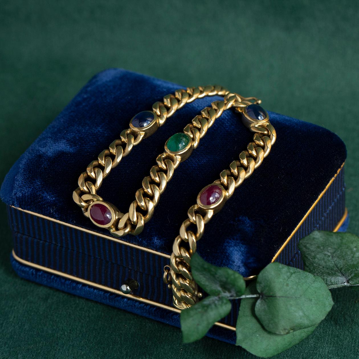 Fabriqué dans l'or jaune 18 carats le plus onctueux, ce bracelet en or massif est orné de rubis, de saphirs et d'émeraudes naturels. Connus sous le nom de 