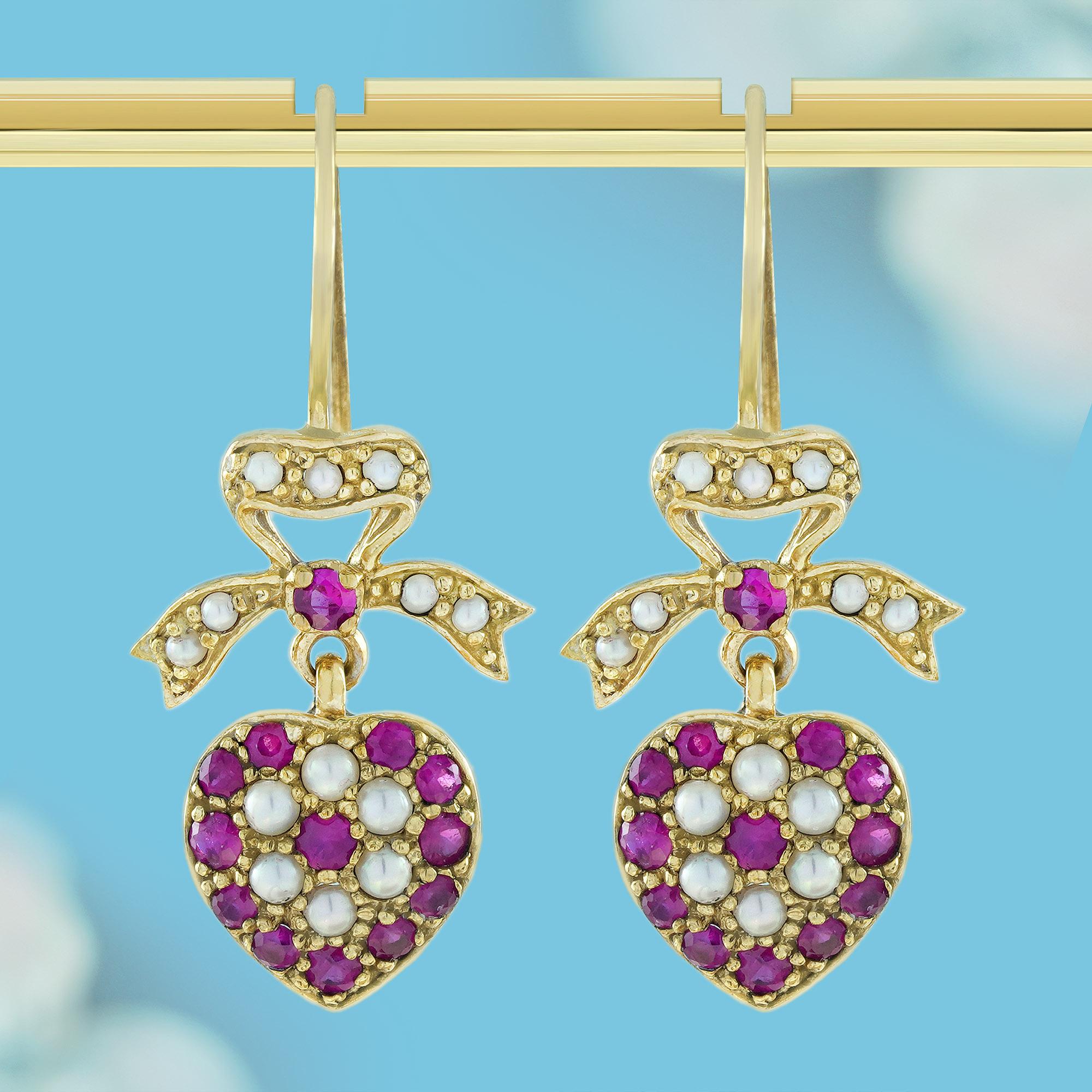 Jeder Ohrring ist mit roten Rubinen und weißen Perlen verziert und hat ein herzförmiges Design, das Liebe und Zuneigung symbolisiert. Die Spitze jedes Herzens ziert eine mit weißen Perlen besetzte Schleife, die in Gelbgold gefasst ist und den bunten