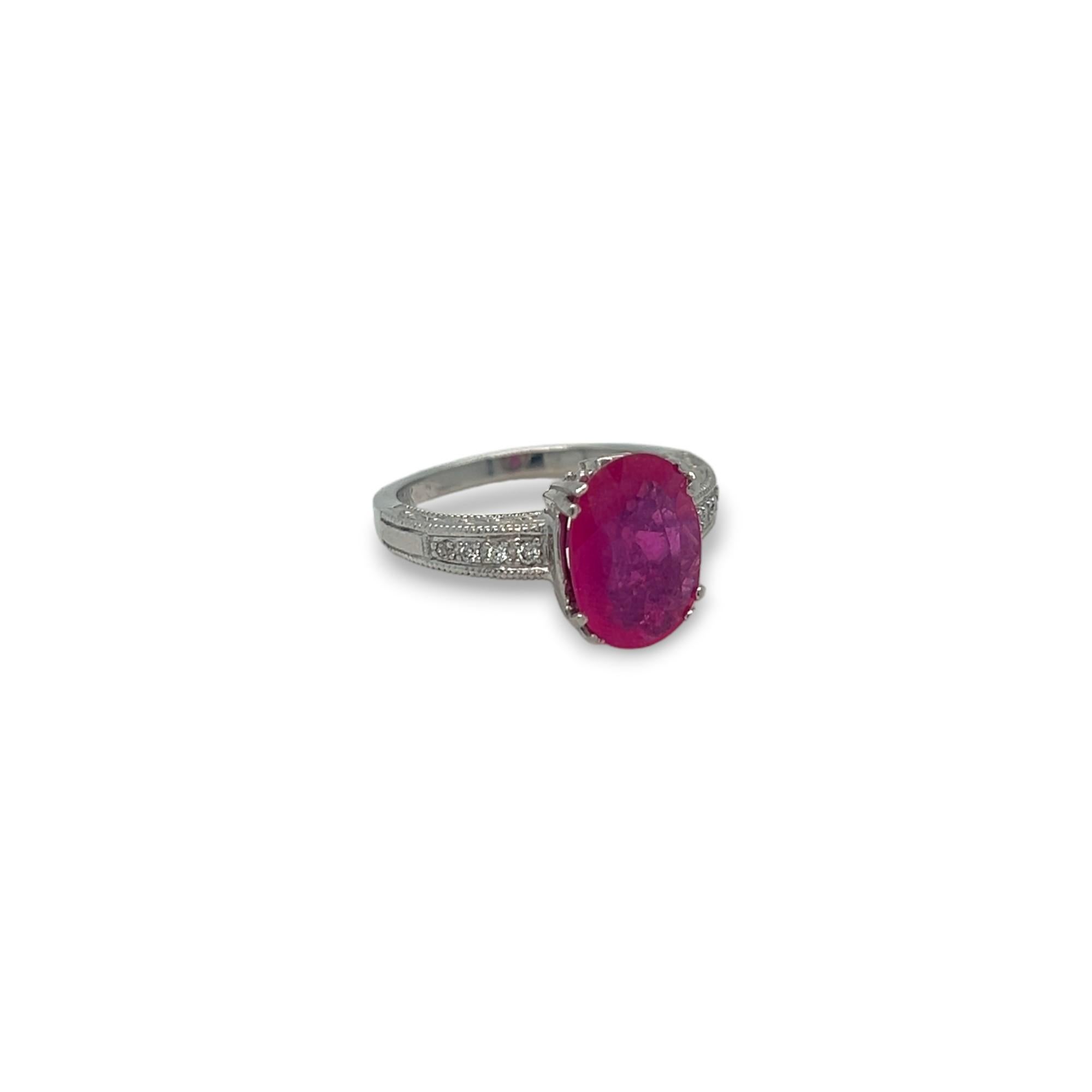 Enhance your jewelry collection with this stunning ring, showcasing a 2.91 carat oval natural ruby as its centerpiece. The elegant 14k white gold band is adorned with round diamonds totaling 0.15 carats and features intricate milgrain detailing.