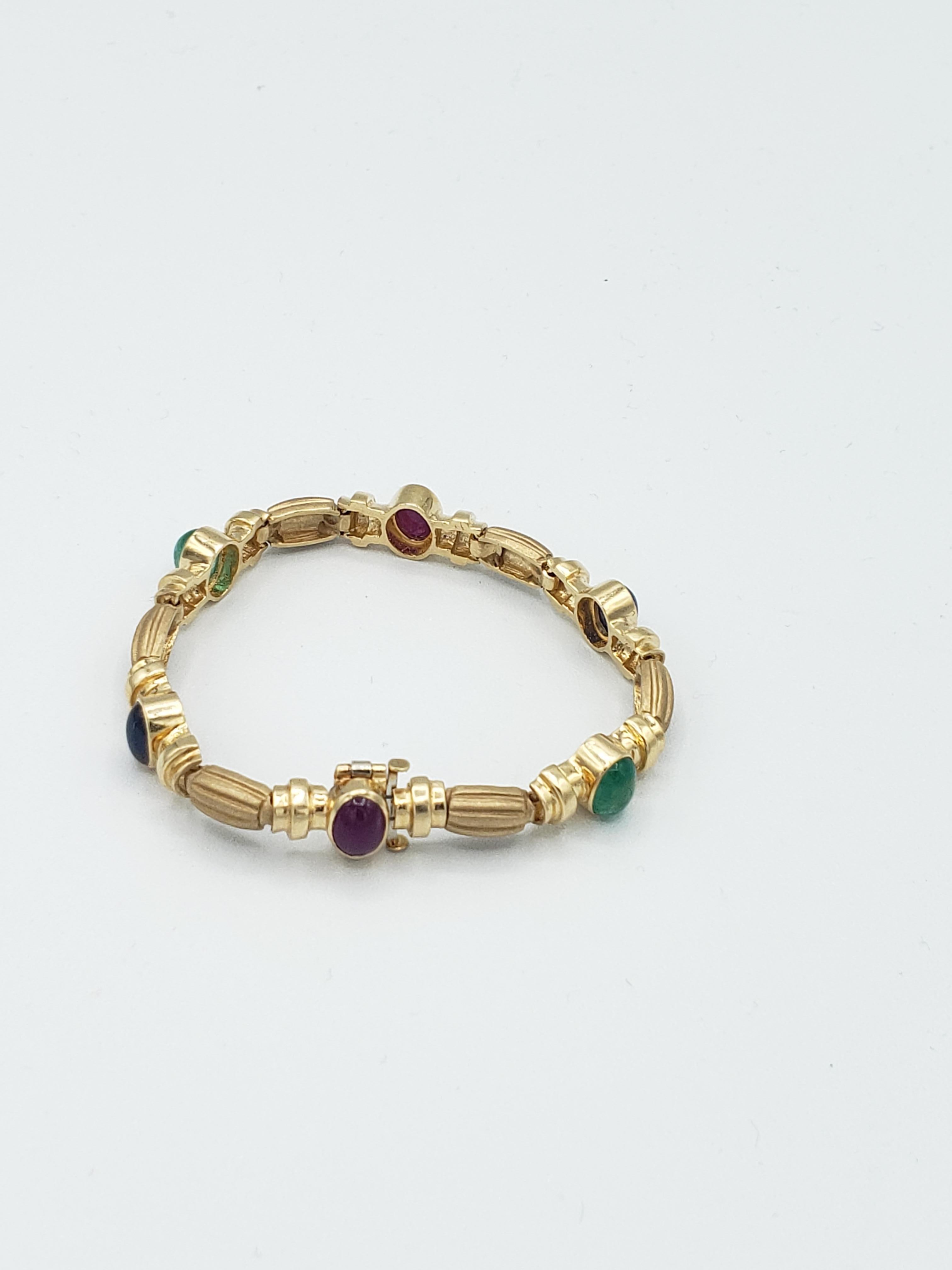 Ce bracelet exquis de LaFrancee est fabriqué en or jaune massif 14 carats et présente de superbes rubis, saphirs et émeraudes naturels. Le bracelet de style byzantin est un clin d'œil à la Nature avec ses détails complexes et ses magnifiques pierres
