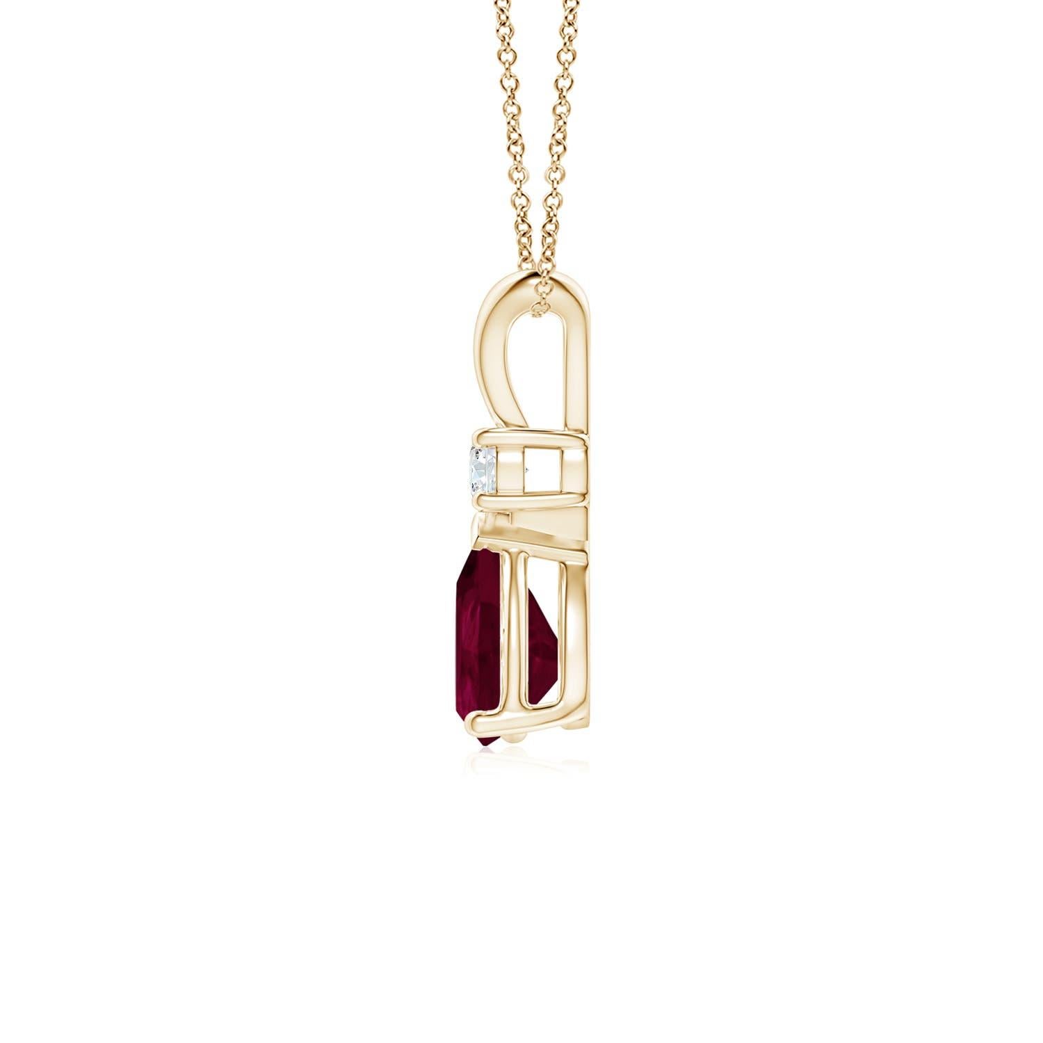 Ce pendentif solitaire classique est orné d'un rubis en forme de poire serti dans une monture à griffes. Un diamant rond brillant surmonte la pierre précieuse de couleur rouge pourpre. Simple mais séduisant, ce pendentif en or jaune 14k orné d'un