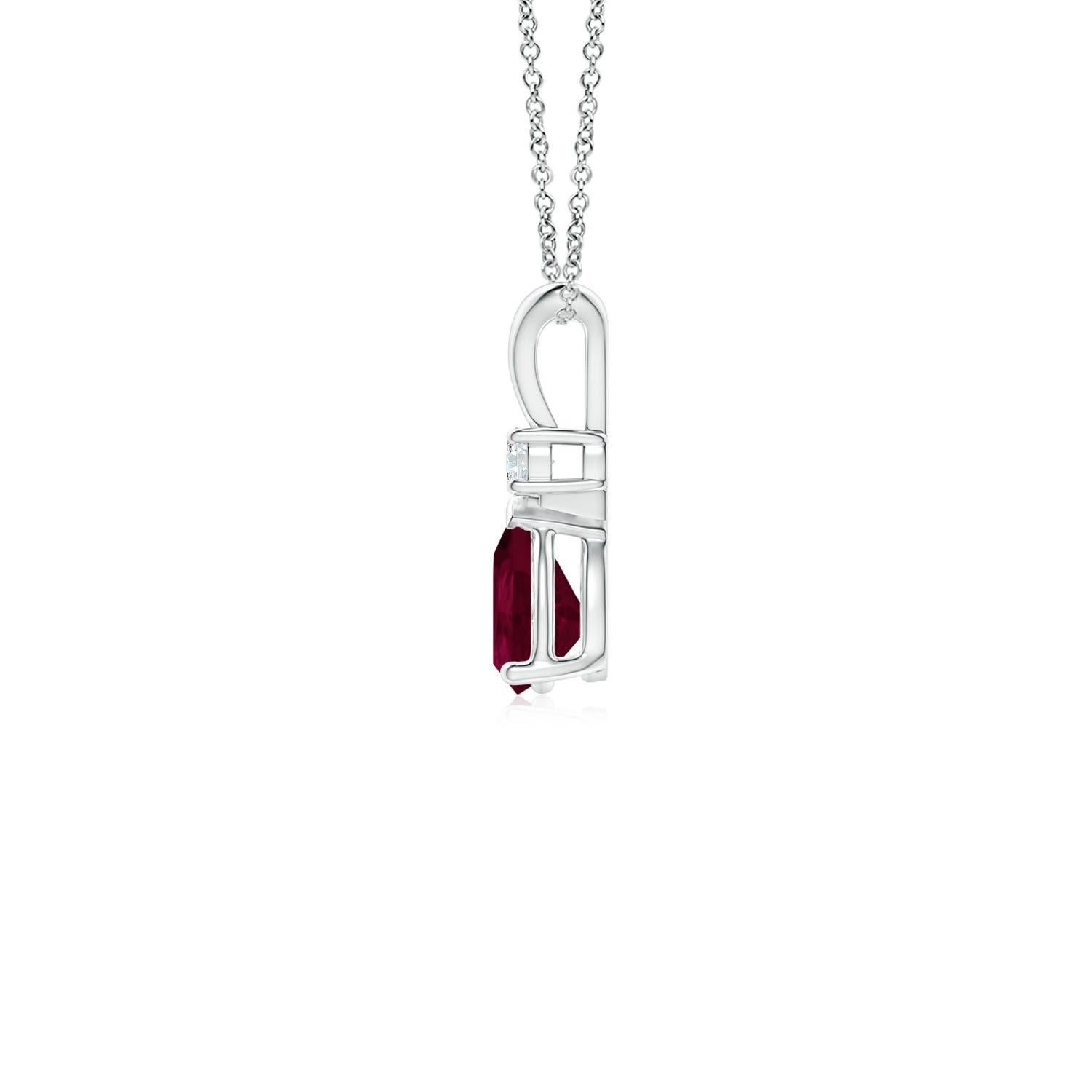 Ce pendentif solitaire classique est orné d'un rubis en forme de poire serti dans une monture à griffes. Un diamant rond brillant surmonte la pierre précieuse de couleur rouge pourpre. Simple mais séduisant, ce pendentif en or blanc 18k orné d'un