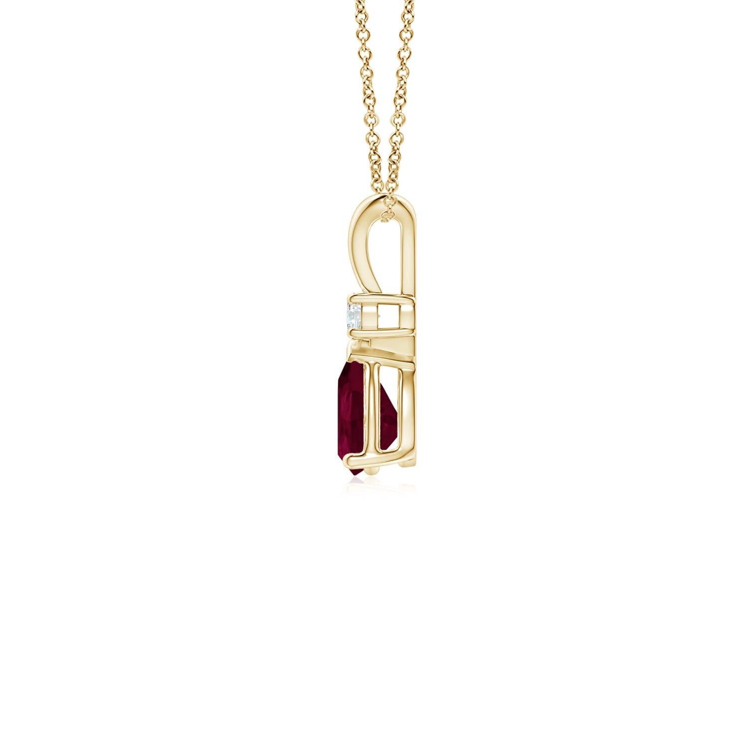 Ce pendentif solitaire classique est orné d'un rubis en forme de poire serti dans une monture à griffes. Un diamant rond brillant surmonte la pierre précieuse de couleur rouge pourpre. Simple mais séduisant, ce pendentif en or jaune 18k orné d'un