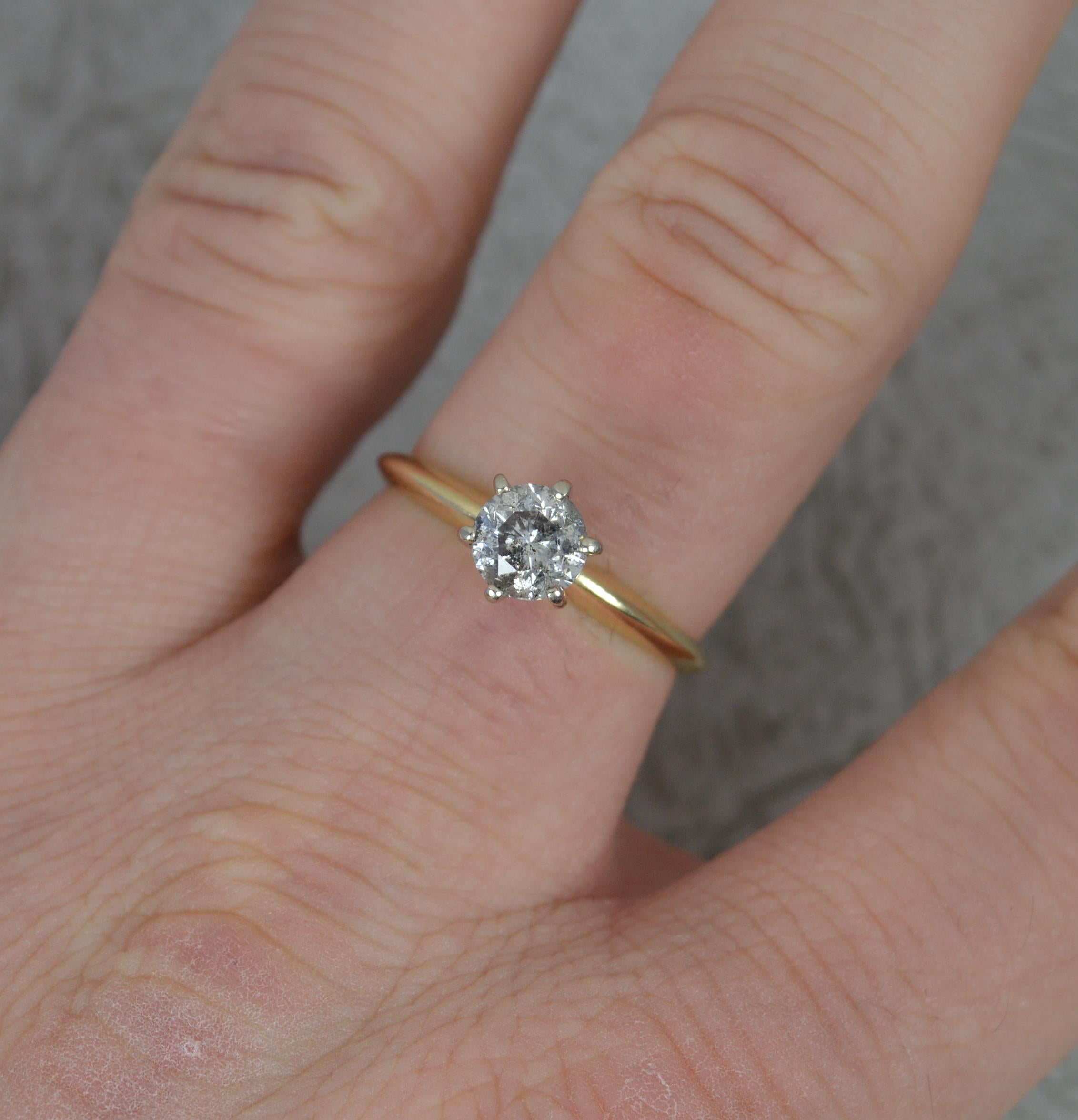 A wonderful diamond engagement ring.
Solid 14 carat yellow gold shank and six claw setting in white gold.
Set with a single, natural, round brilliant cut diamond. 5.7mm diameter, 0.7cts approx. Untreated. 
Known as a salt and pepper diamond, natural